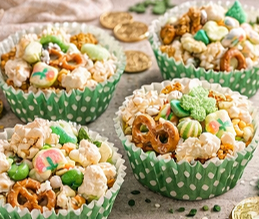 St. Patrick’s Day snack mix with popcorn, pretzels, green M&Ms, Lucky Charms marshmallows, and white chocolate drizzle.
