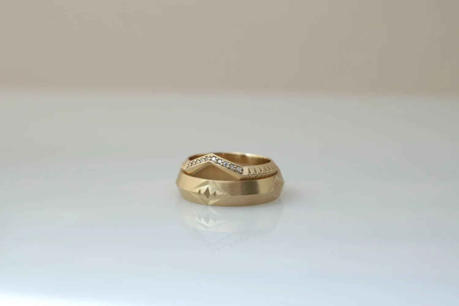 Gold ring with a hammered texture and a V-shaped row of small diamonds.