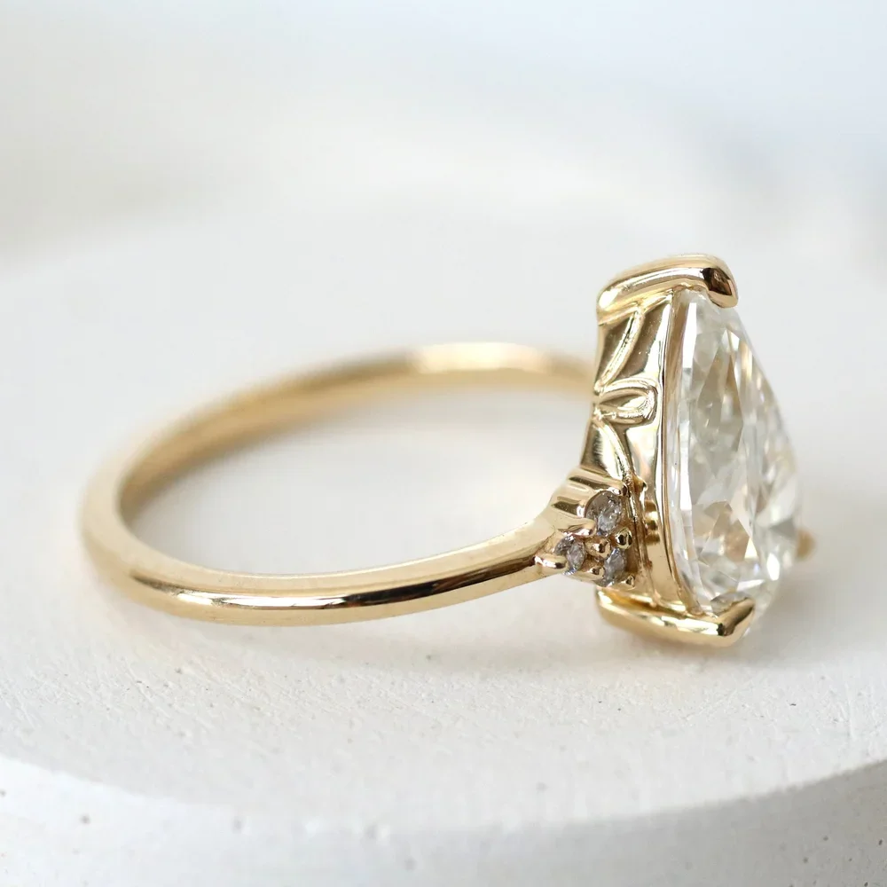 Close-up of a gold ring with a large diamond and smaller accent diamonds on the band.