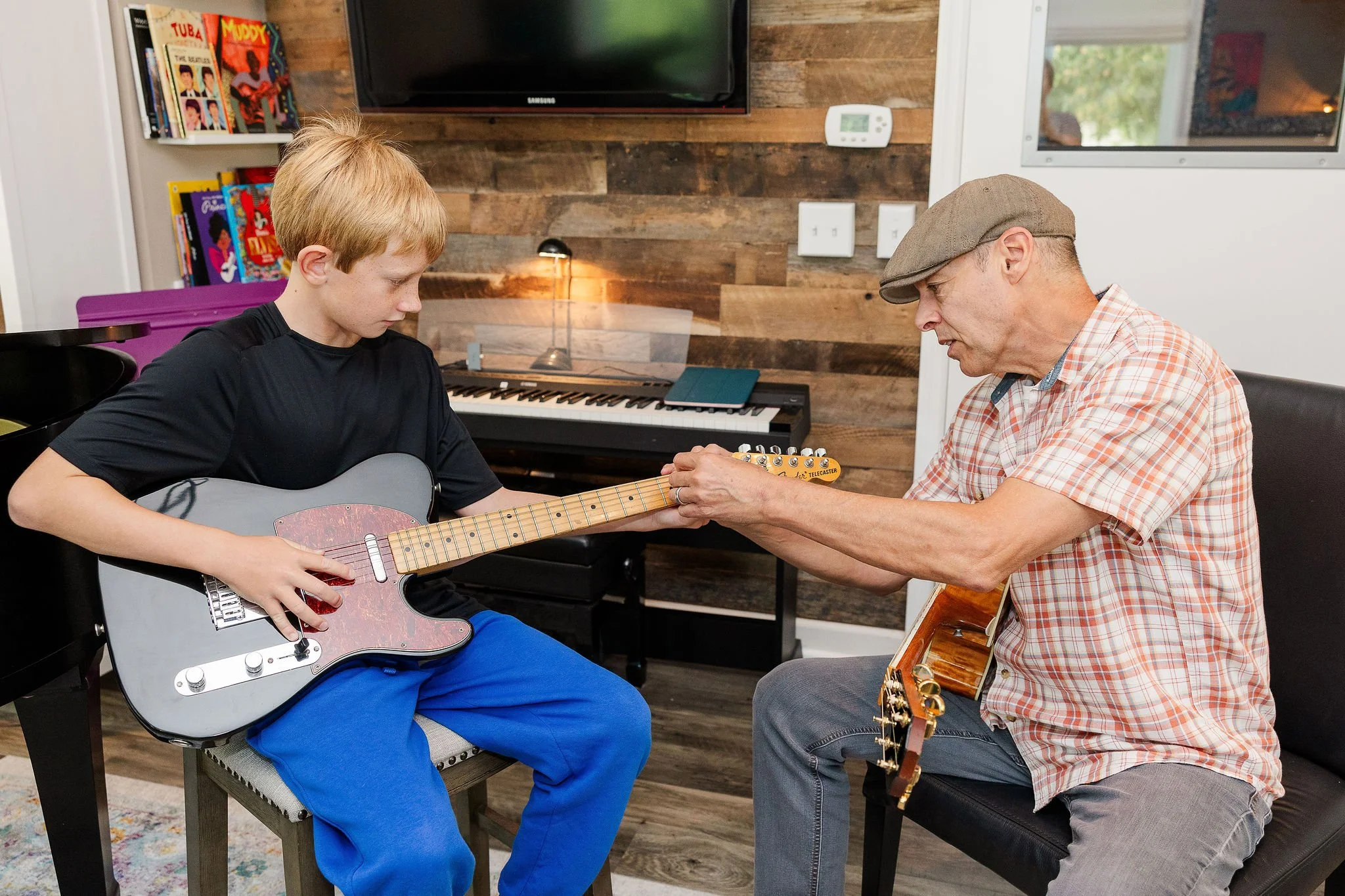 A young boy with blonde hair playing an electric guitar while playing the blues. He is enjoying his contemporary guitar lessons with high ranked instruction in the Lake Elmo music lesson studio.