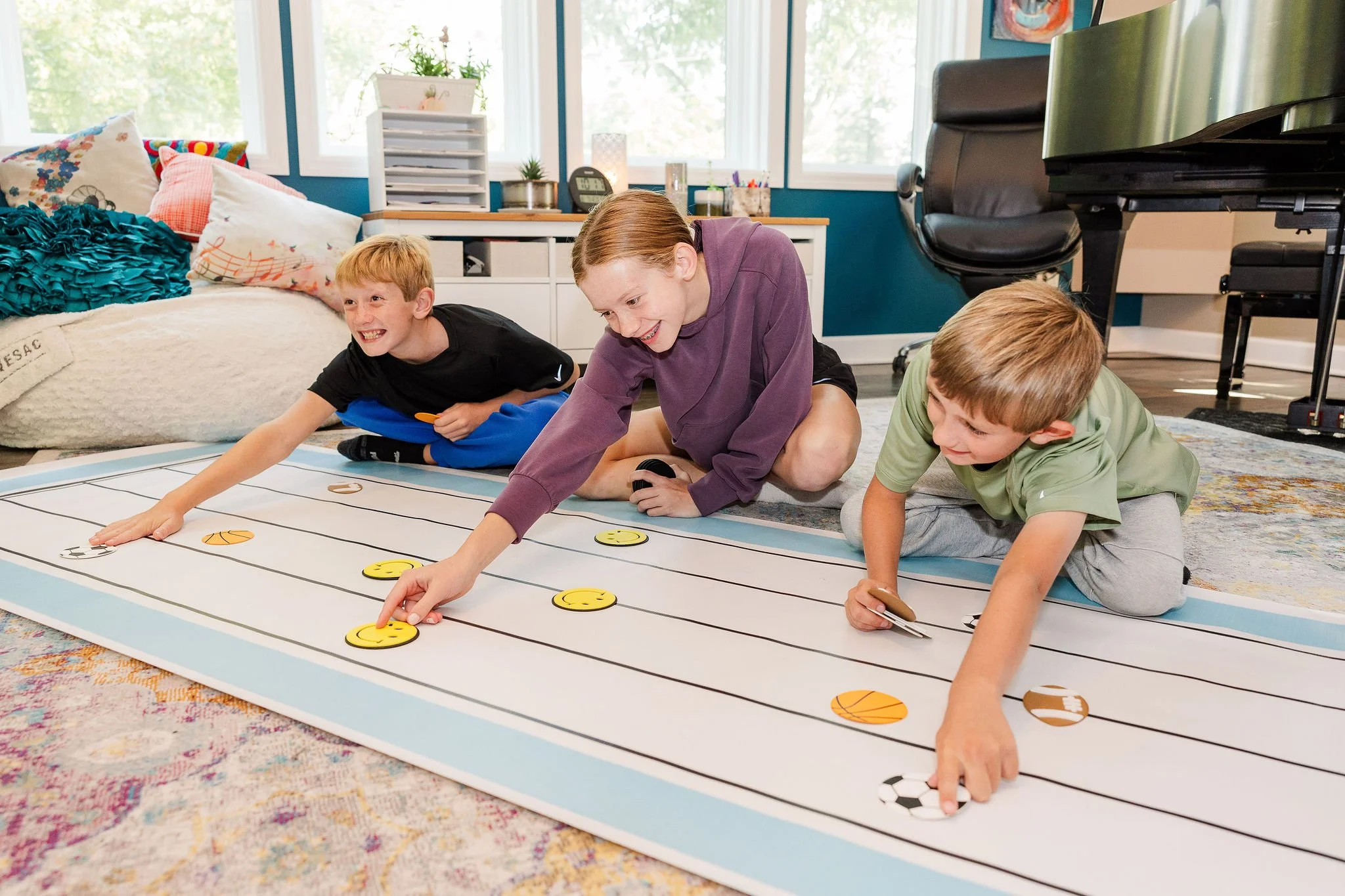 Three children having fun playing games at piano lessons in Lake Elmo, MN.