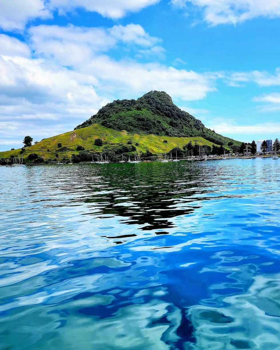 As you cruise with us, you’ll spot the iconic Mount Maunganui—but did you know it has two names and two very different meanings?
'Maunganui' simply means "big mountain", which makes sense when you see how it towers over the coa