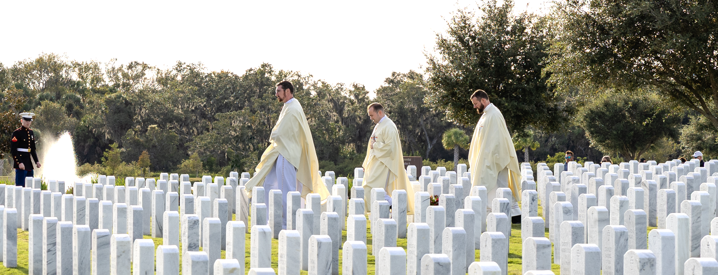 three priests in veteran's graveyard.png
