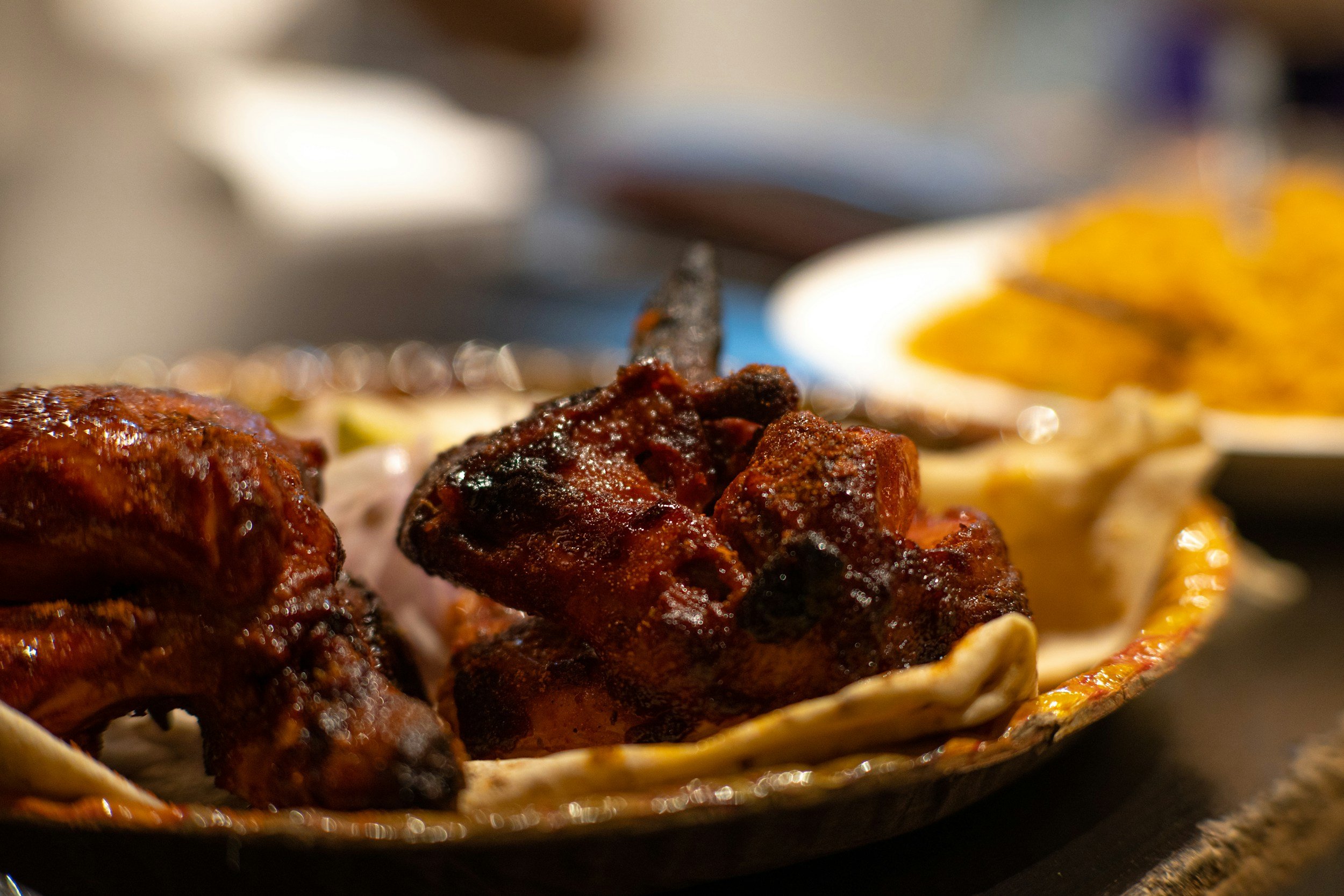 Close-up of grilled chicken and steak with side dishes on a decorative plate.