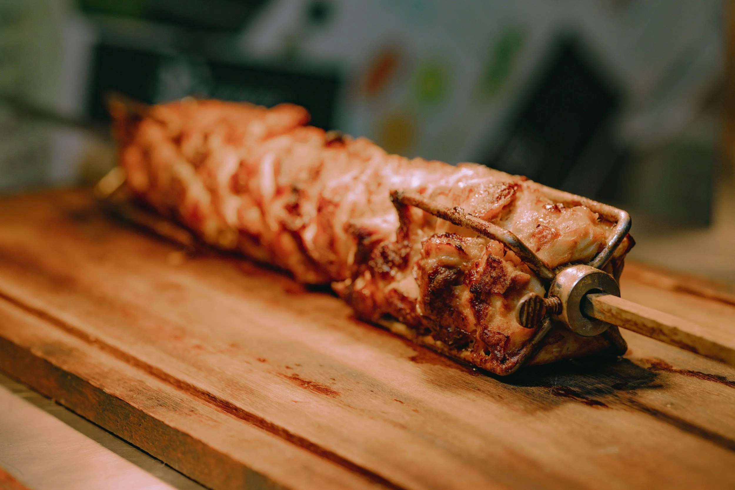 Cooked meat rolling on a wooden surface