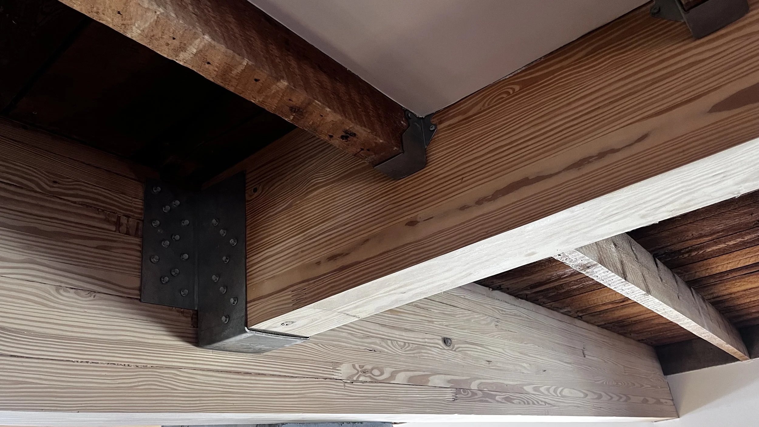 mass timber glulam beam hanger detail and exposed solid sawn timber ceiling