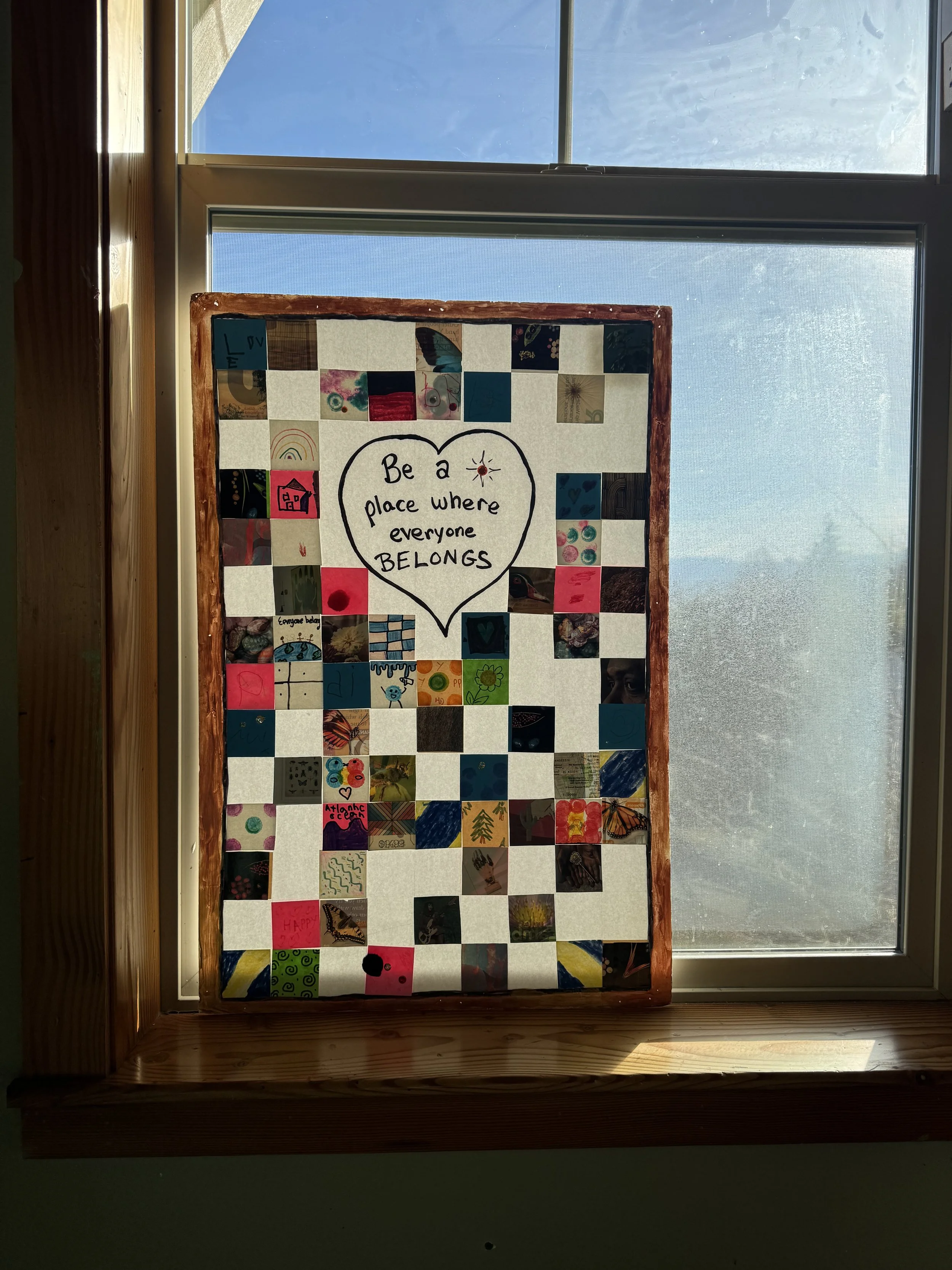 window decoration stating "be a place where everyone belongs"