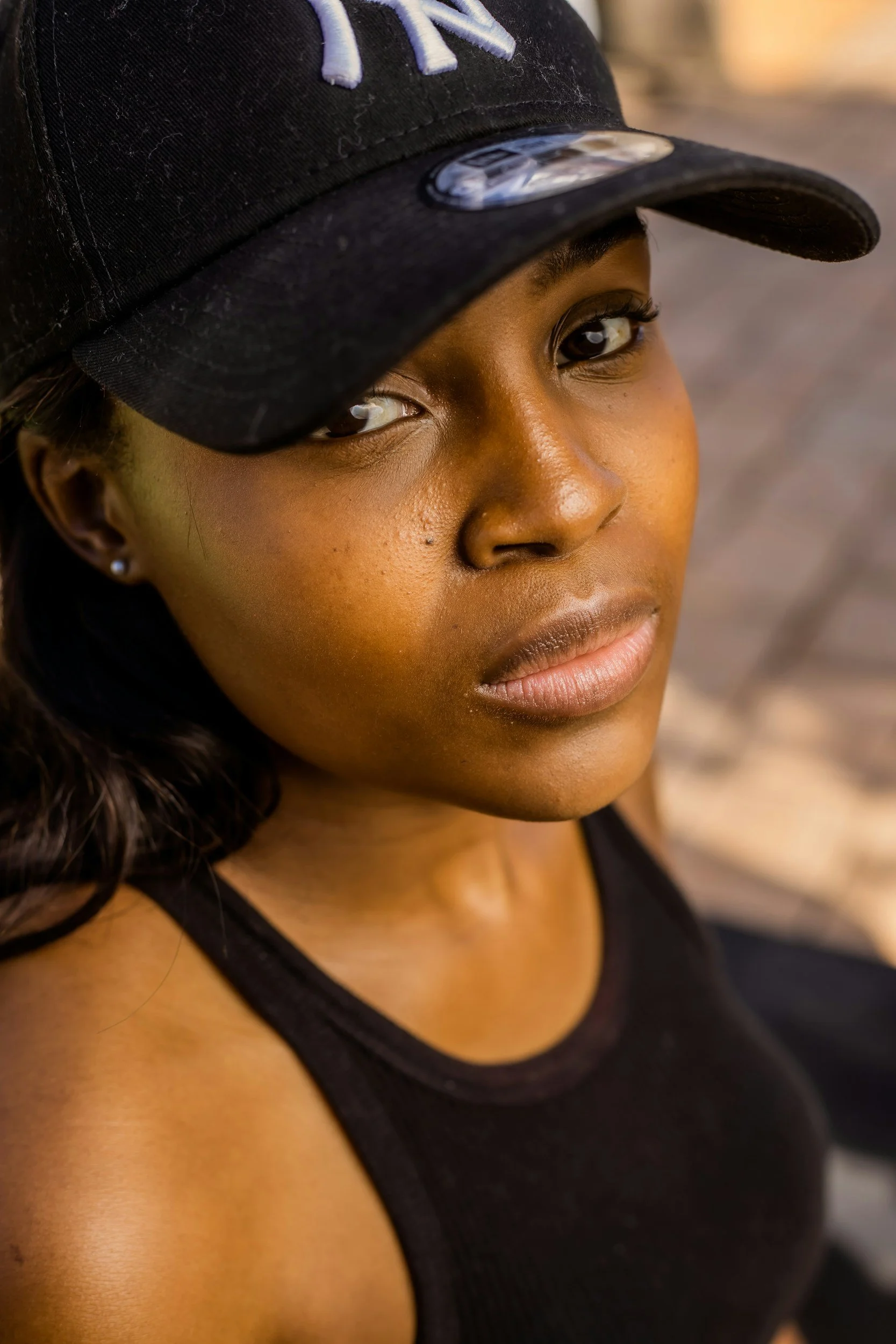 Une femme portant une casquette noire regarde l'objectif.