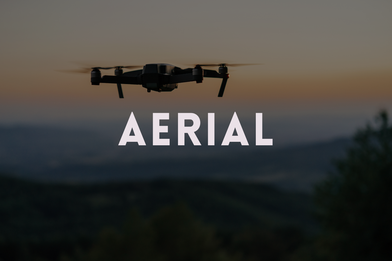 A drone flying in the sky at sunset with the word 'AERIAL' overlaid.