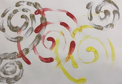 Colorful swirls in red, yellow, and silver on white paper.