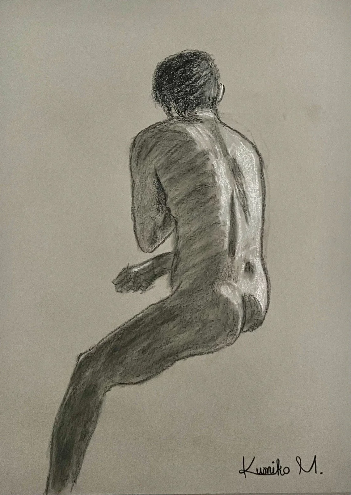 A realistic pencil sketch of a nude man sitting with his back to the viewer, head turned slightly to the right, with detailed shading showing muscle tone and hair texture, signed by Kumiko M.