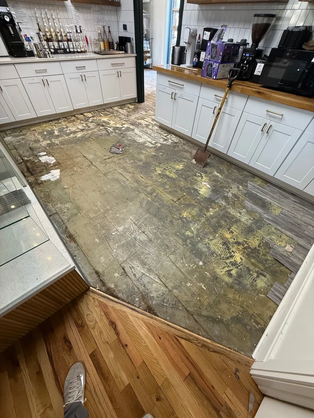 Flooring removal in Wichita, KS: old flooring and adhesive stripped down to the subfloor