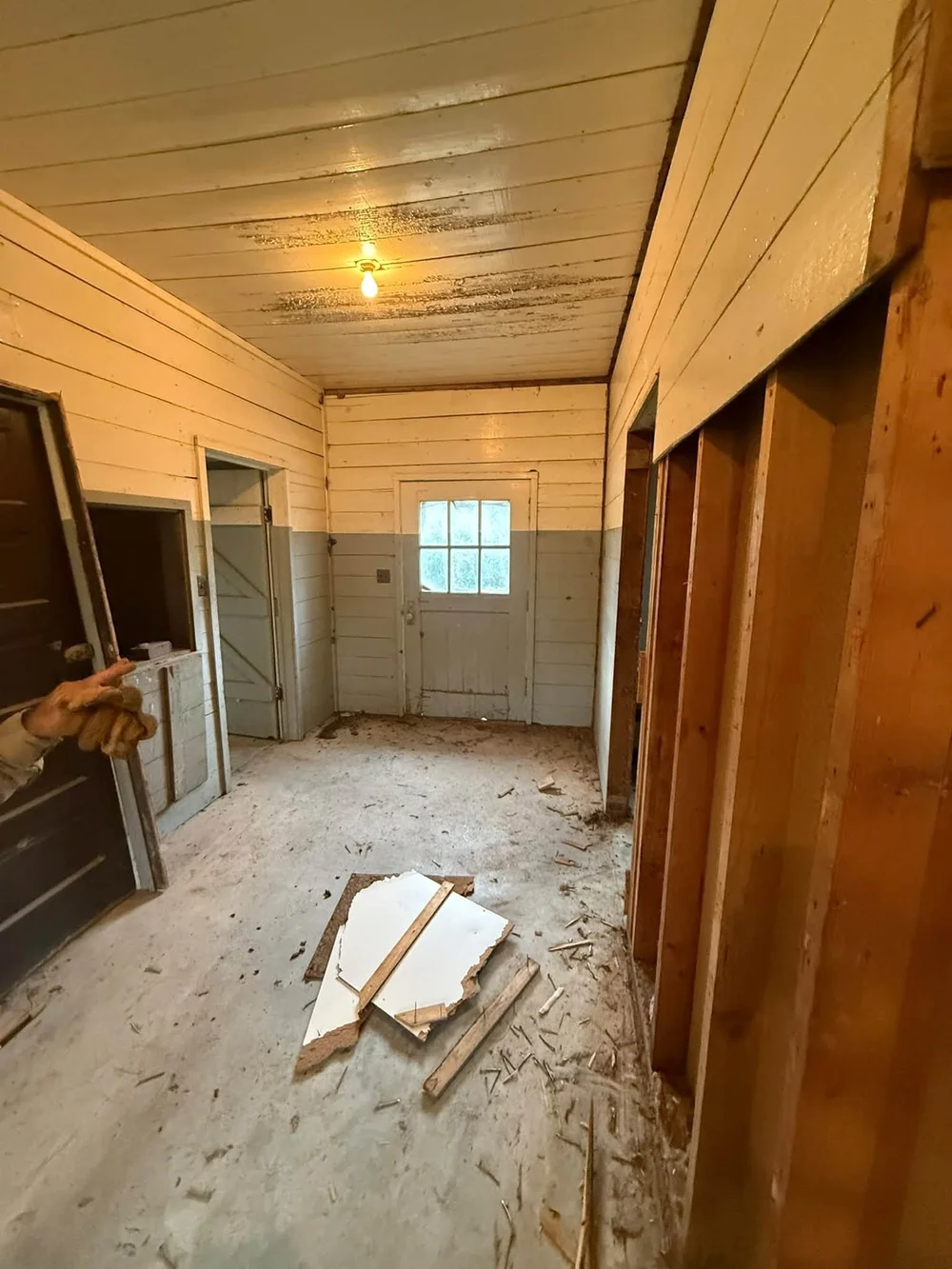 Interior demolition in Wichita, KS: hallway wall torn open to the studs with debris cleared