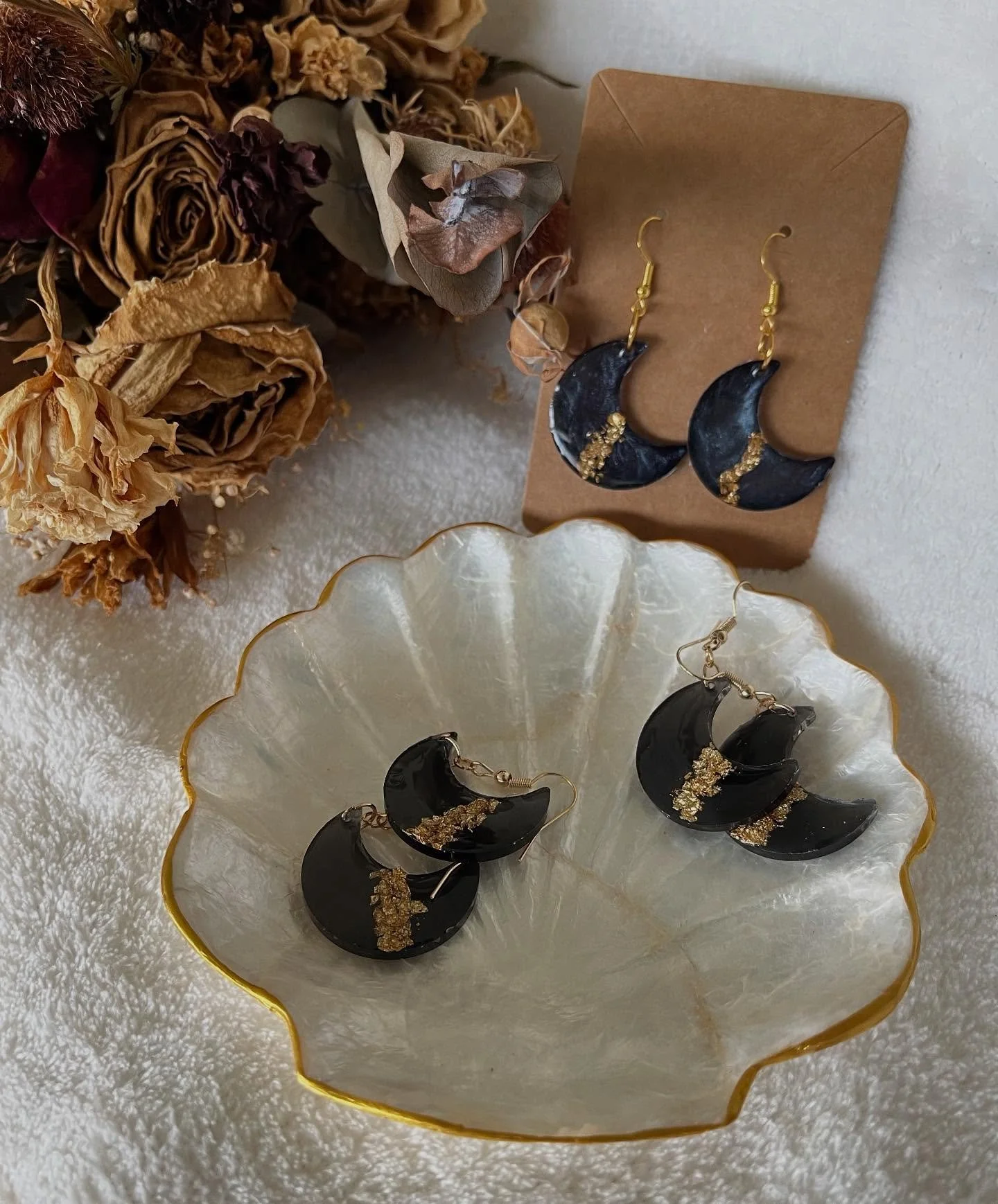 Astrid

A quiet ode to the night sky. These crescent-shaped resin earrings feature a deep black base flecked with shimmering gold dust, reminiscent of stars scattered across a midnight sky. Elegant, bold, and a little celestial &mdash; for dreamers a