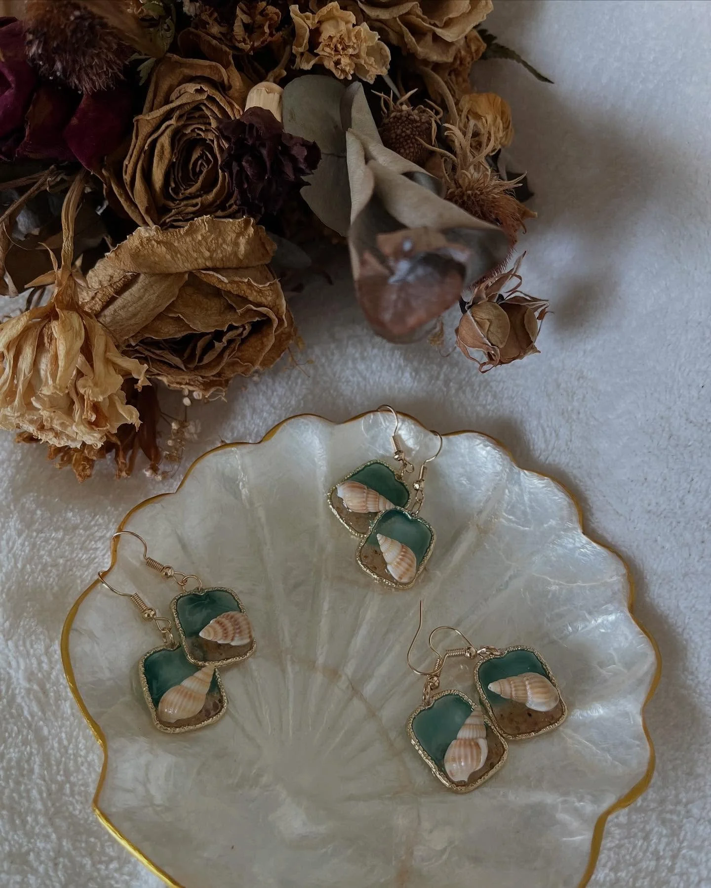 Isla 

A delicate seaside daydream - Soft swirls of ocean blue and white, tiny seashells, and grains of sand encased in a gold textured bezel. Light, graceful, and perfect for those who carry the sea with them.