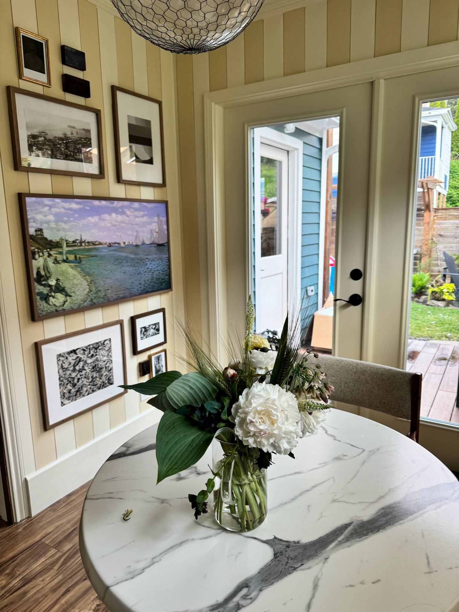 A cleverly hidden frame tv among art, creates a nice place to have morning coffee