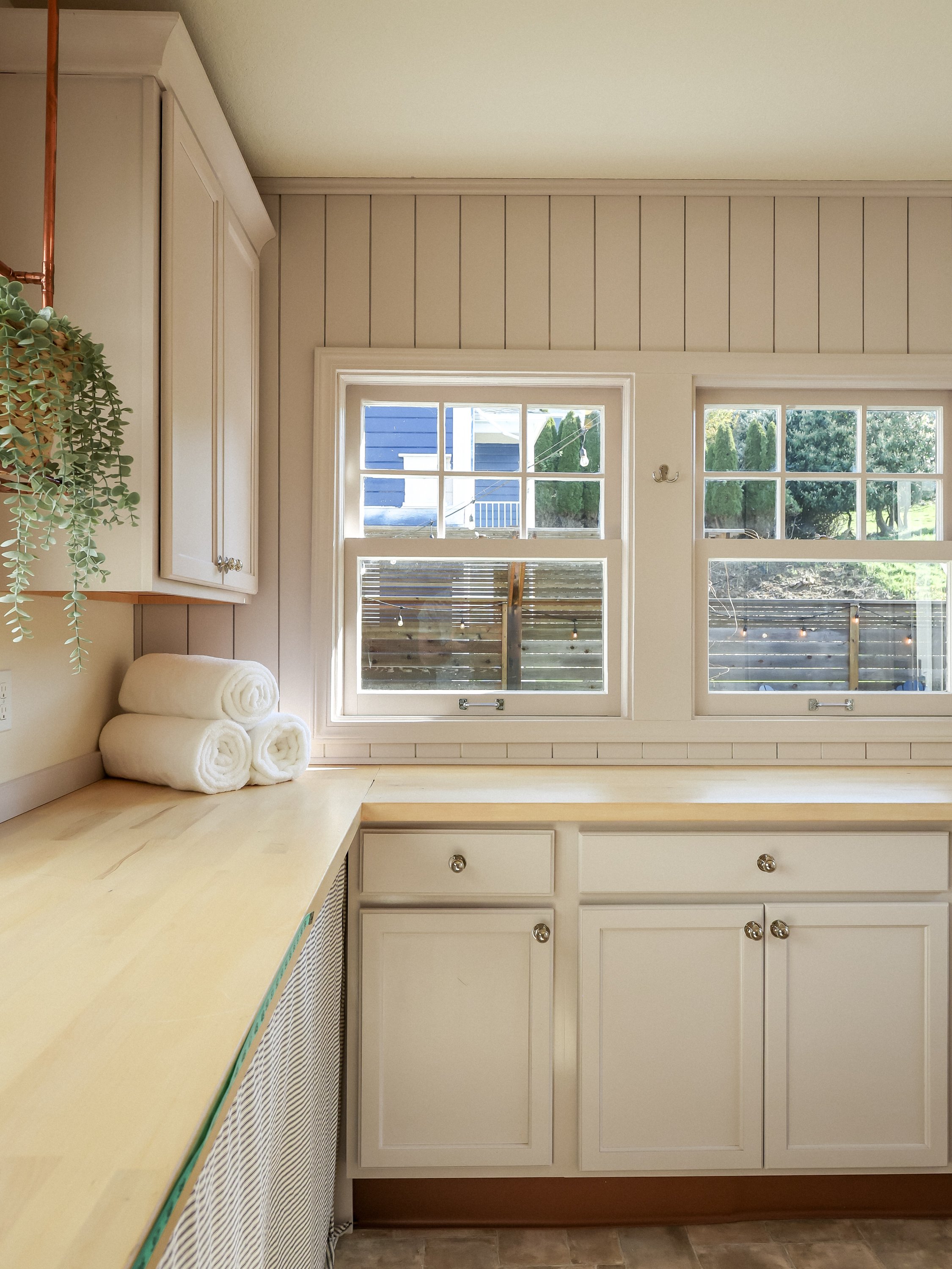 The fix: The butcher block counter adds ample space for folding clothes. Under the counter the bikes are stored. Ship lap lines the room that is drenched in farrow and ball shade of pink.