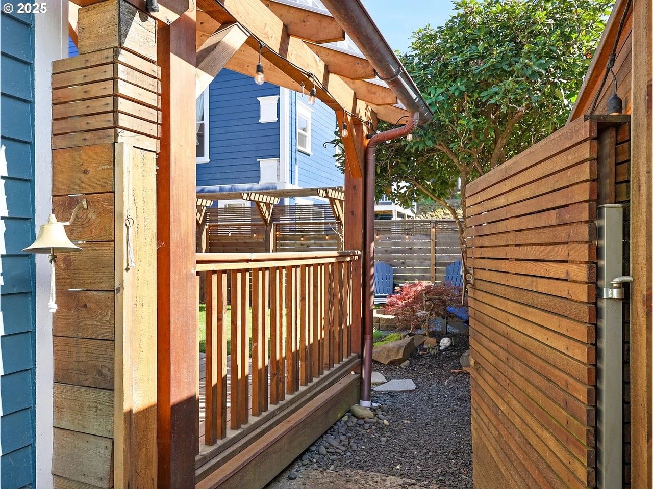 A beautiful cedar gate welcomes guests. A copper gutter blends with the cedar and directs water to a French drain system.