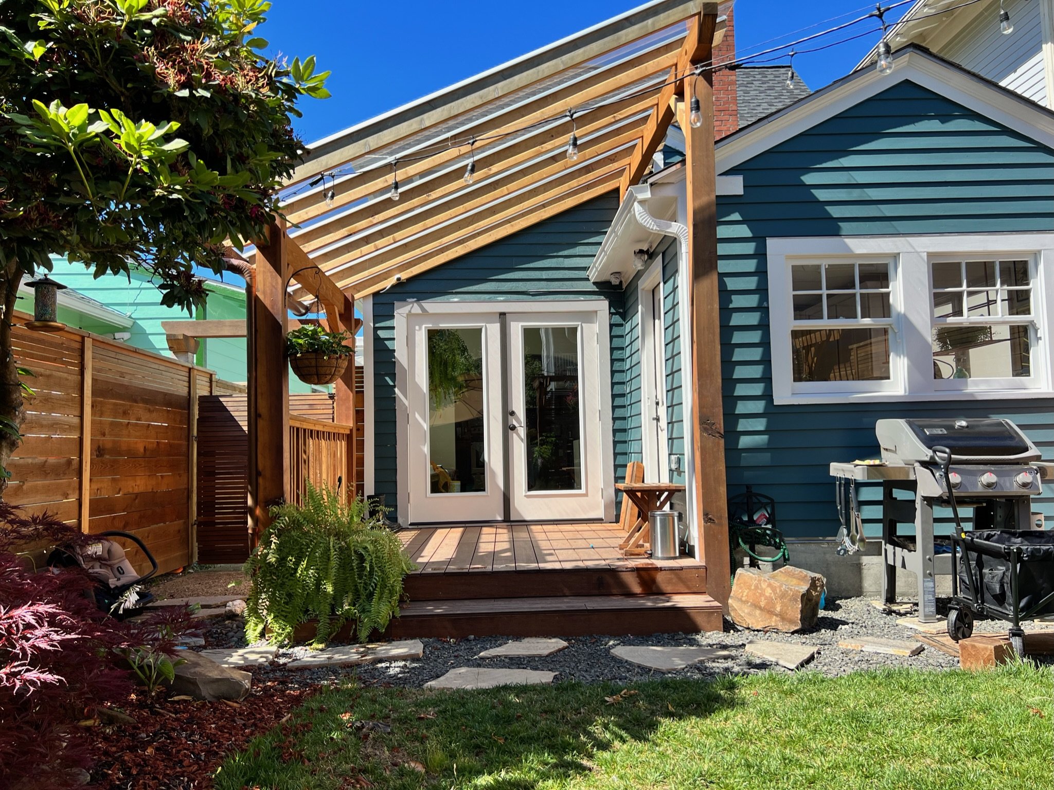 The fix: Locally milled cedar fence and pergola was designed in coordination with the historic society. The pergola is covered with a high wind rated polycarbonate system. French doors were installed for direct access. The decking is a resin/bamboo c