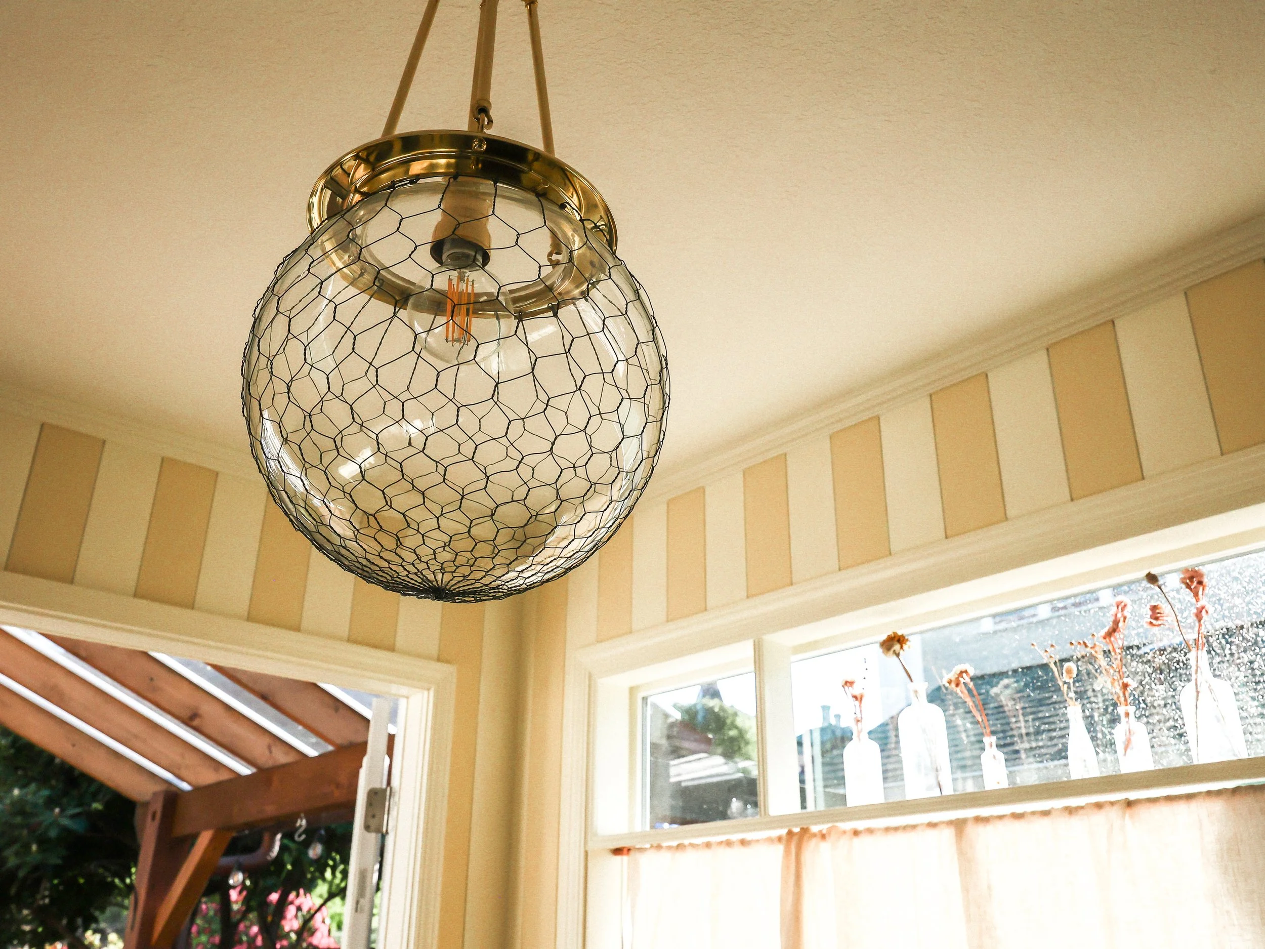 A reproduction hand blown glass pendent hangs in the parlor room