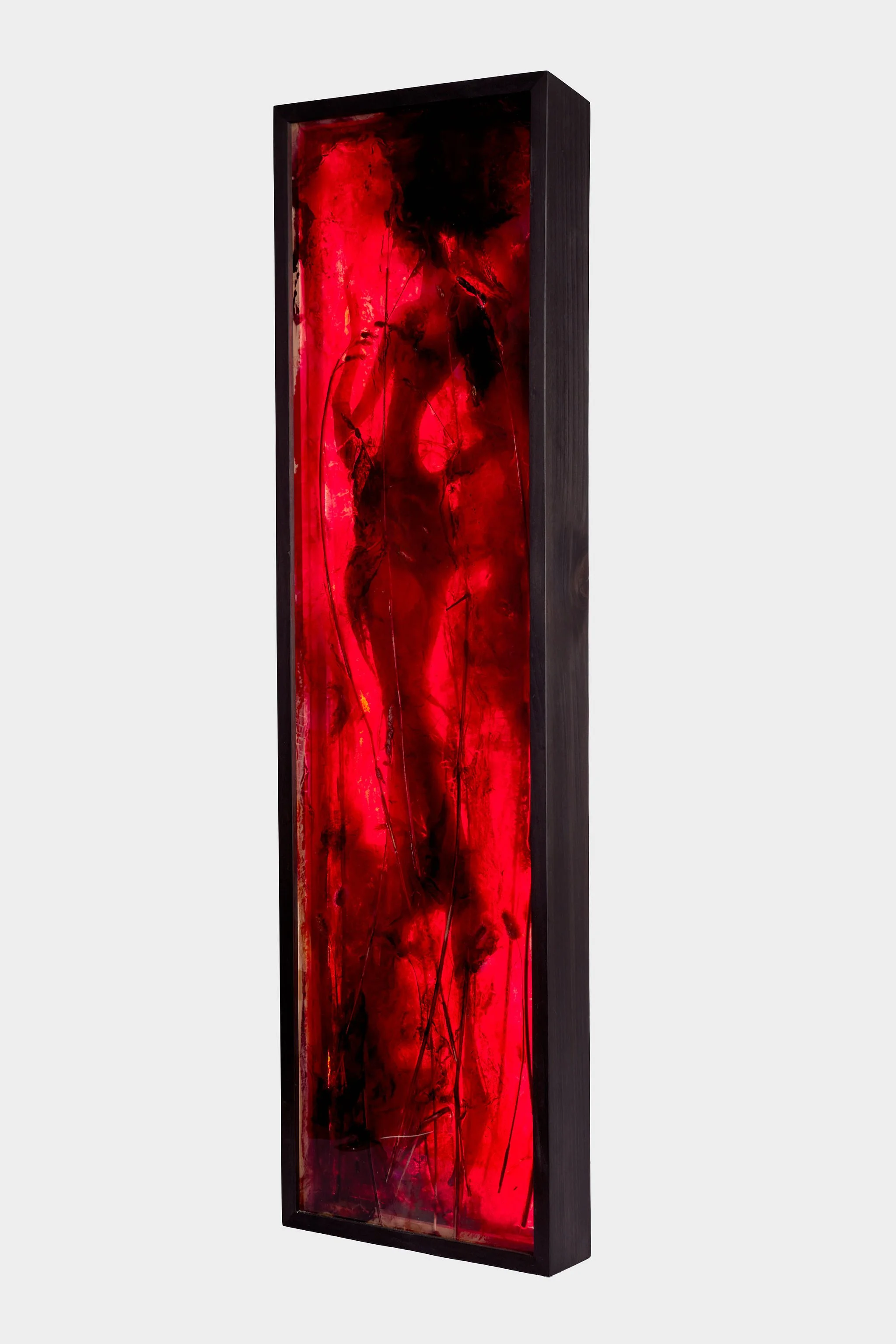 Tall black-framed artwork featuring a female figure, with strong red resin light behind.