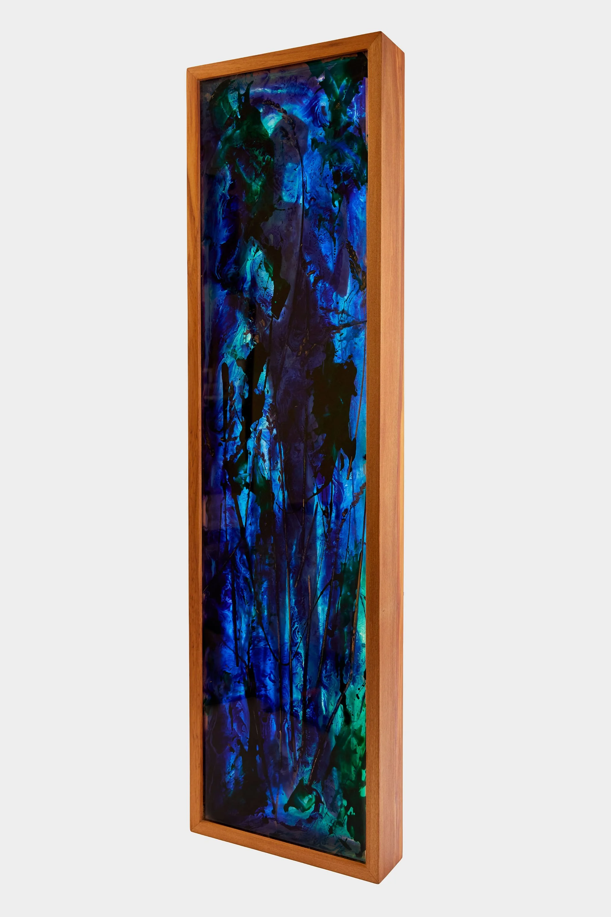 A tall, vertical abstract painting with blue, green, and black colors in a wooden frame with a woman figure.