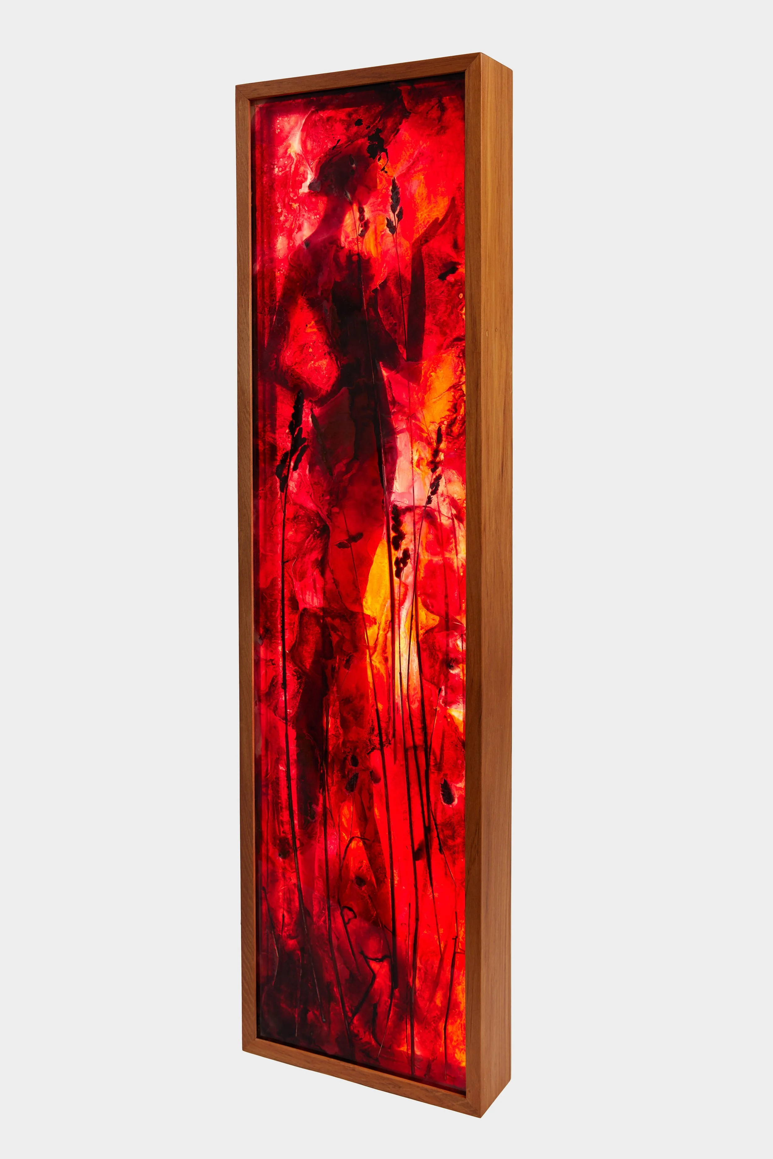 Tall vertical wooden framed light piece featuring an abstract fiery red, orange, and black scene with a silhouette of a woman and native new zealand grasses in resin.