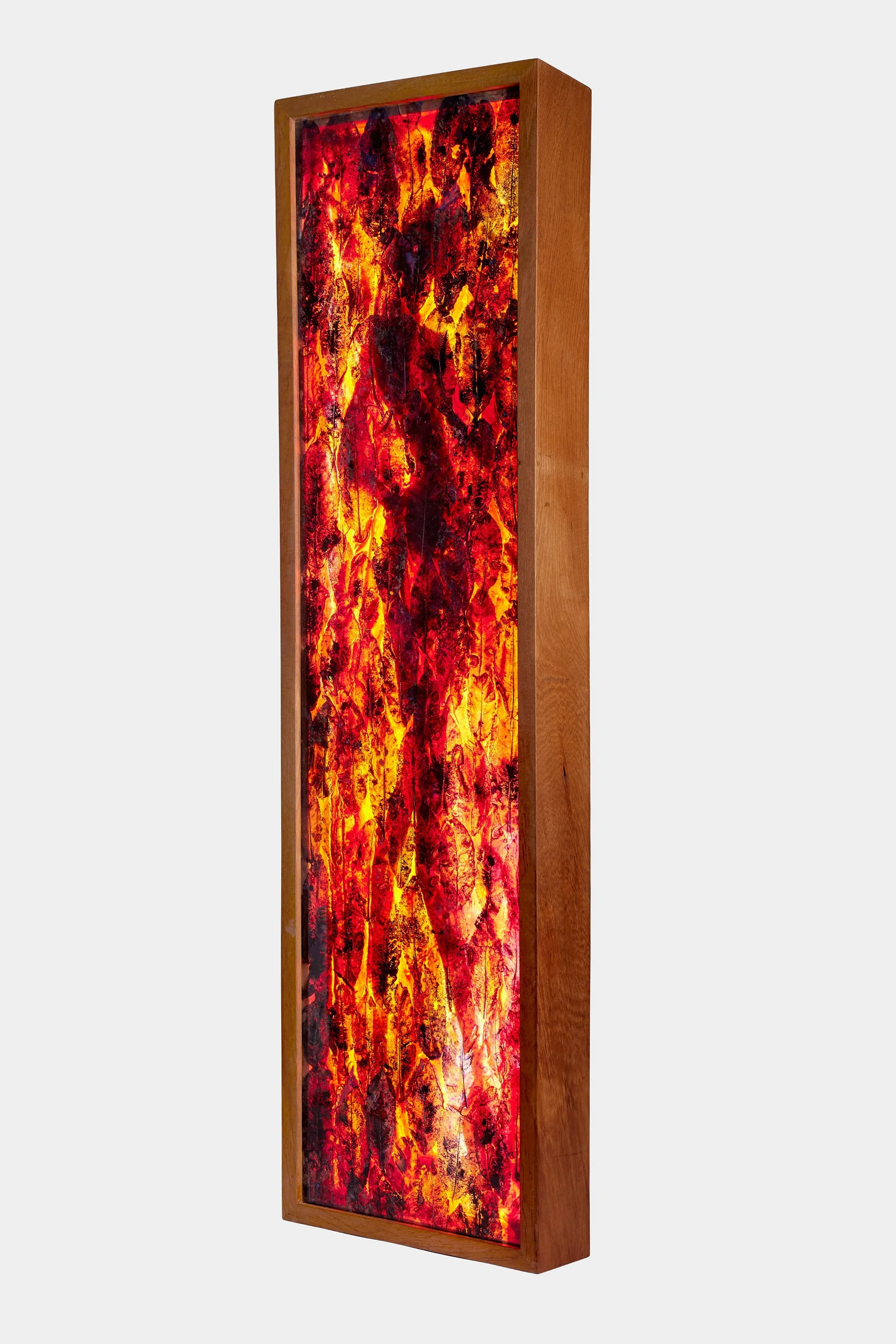 Resined mahoe leaves in framed in a light rectangle with a female figure.