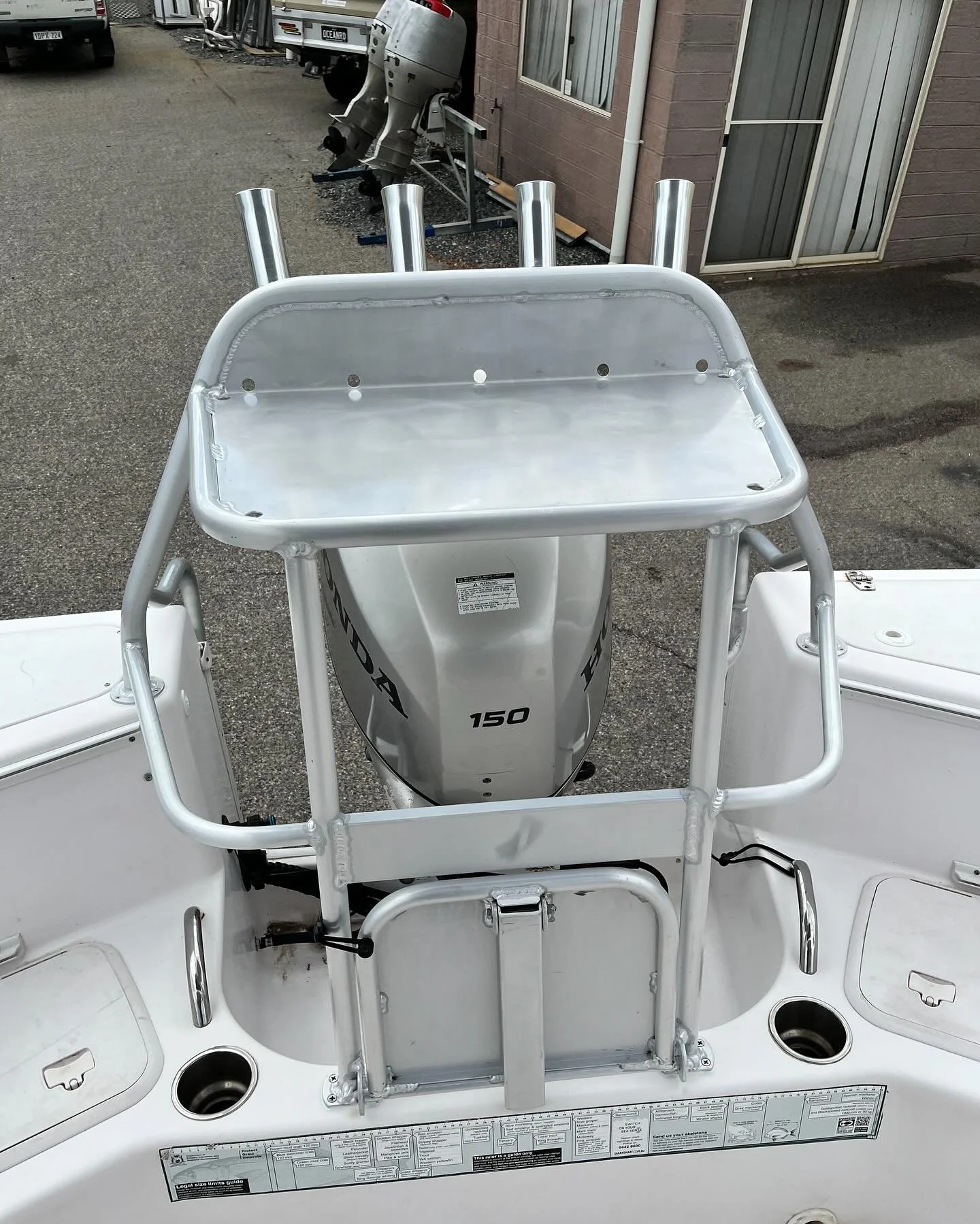 A boat with a mounted outboard engine labeled 'Honda 150' and a metal platform with four vertical tubes on top.
