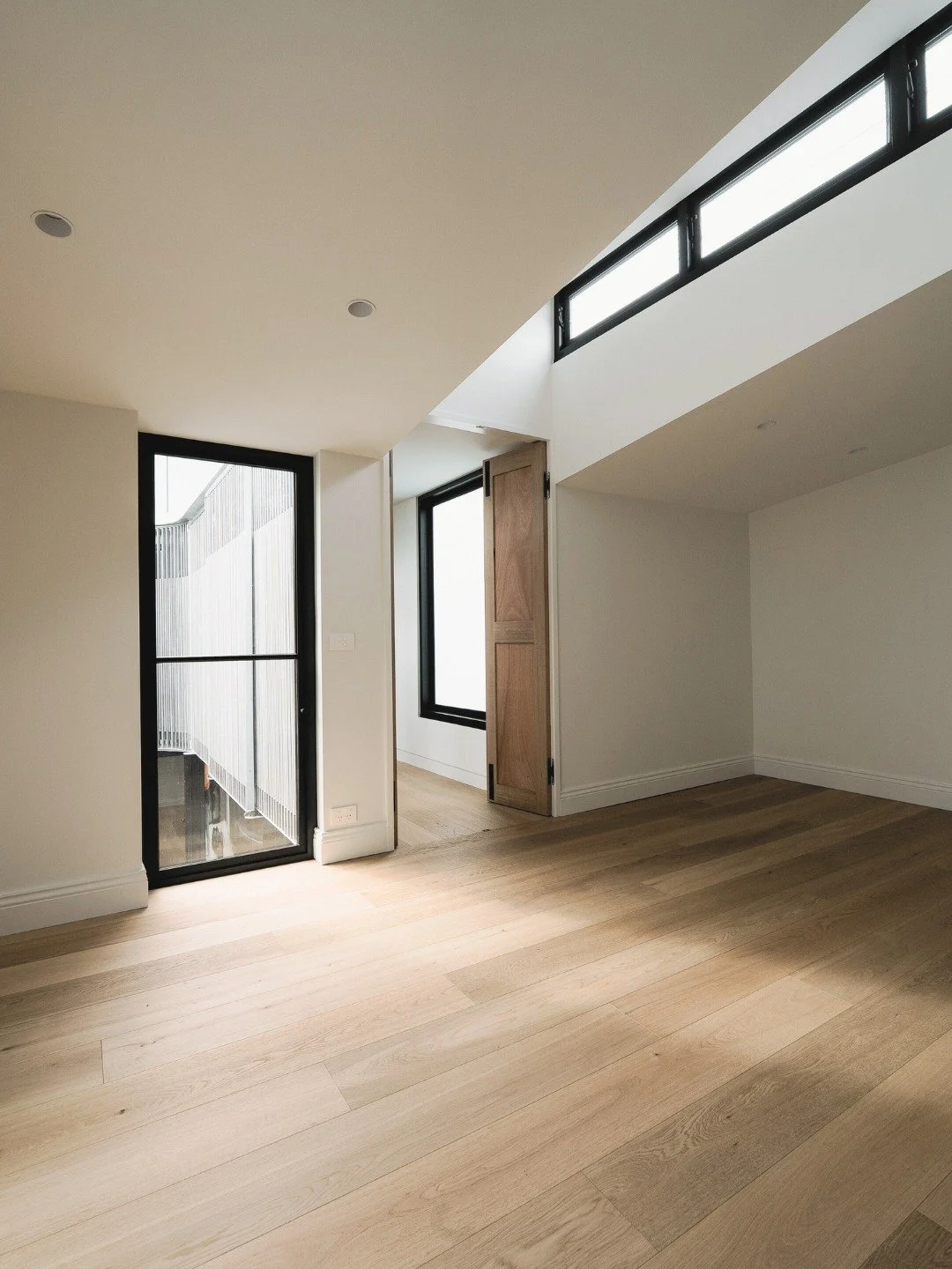 Some rooms just feel different when natural light does the work.

This features windows that flood the space with light from above, while black-framed windows connect to the internal courtyard below. 

High ceilings, quality timber floors, and a conn