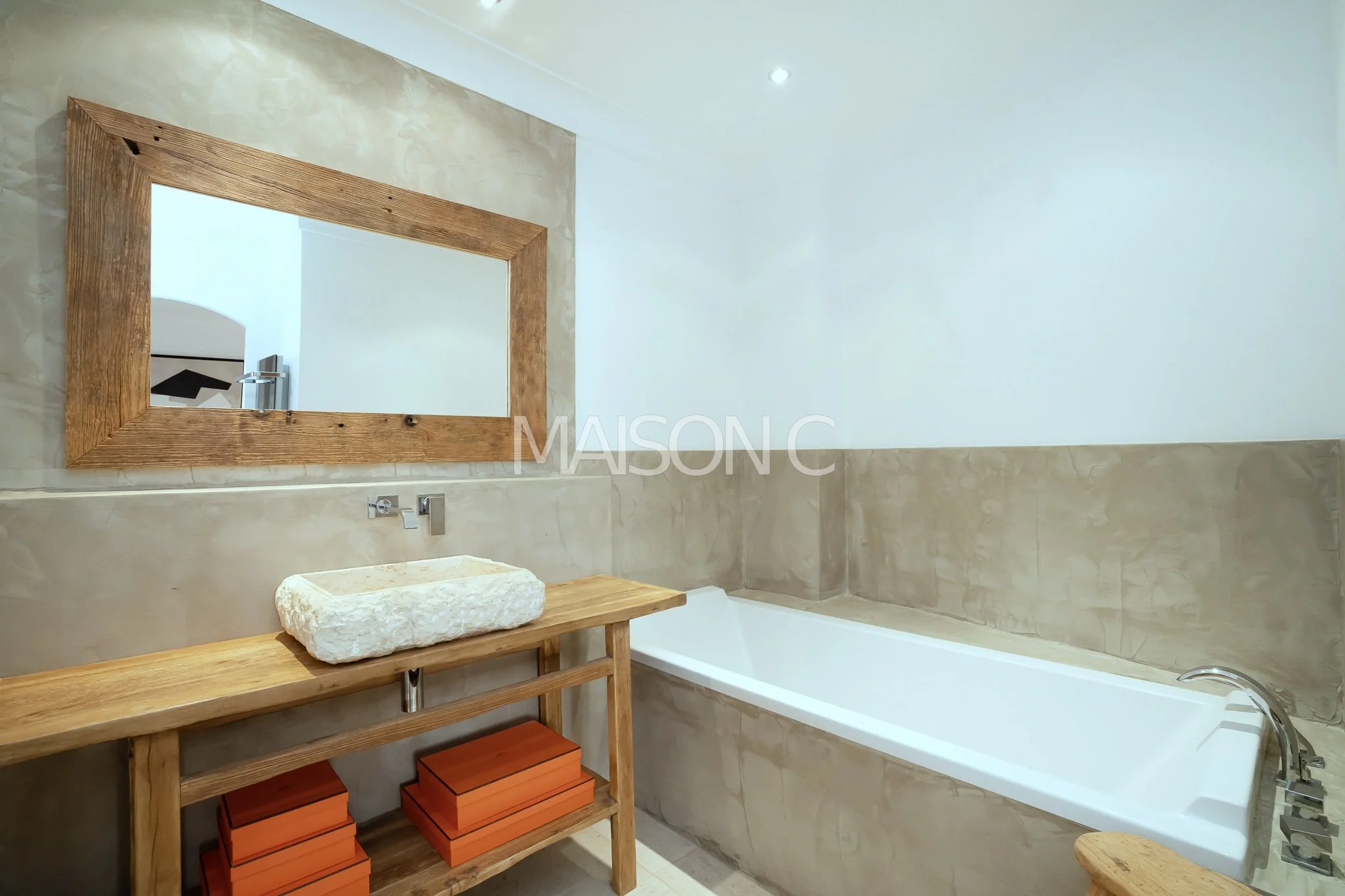 Salle de bain moderne avec baignoire, miroir en bois et lavabo en pierre