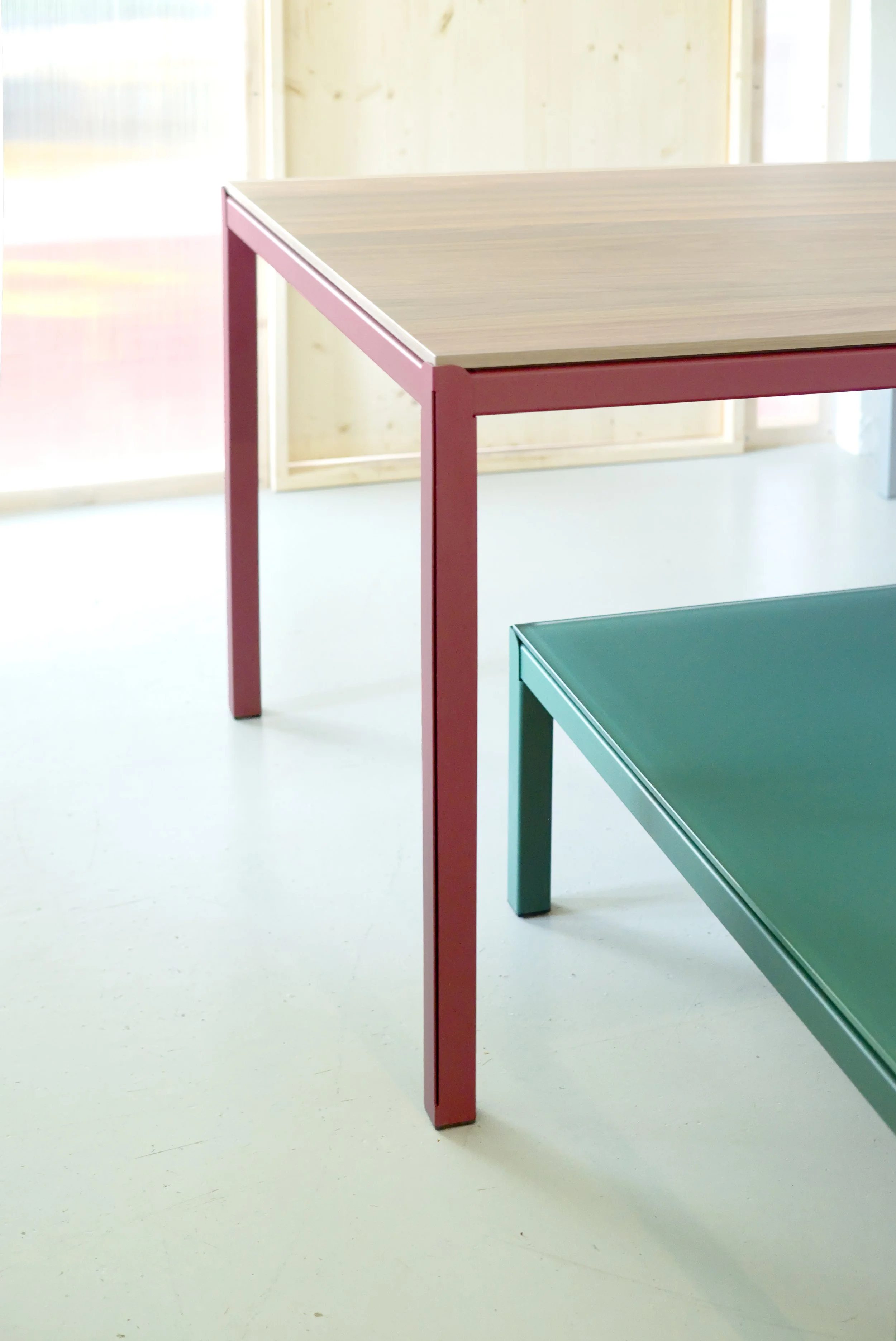 Twee kleurrijke tafelbladen, één met een roze frame en het andere met een groene frame, in een lichte kamer.