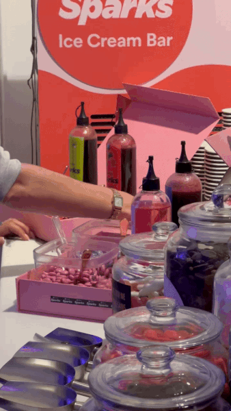Assorted colorful bottles and jars on a table at a Sprinkles Ice Cream Bar event.