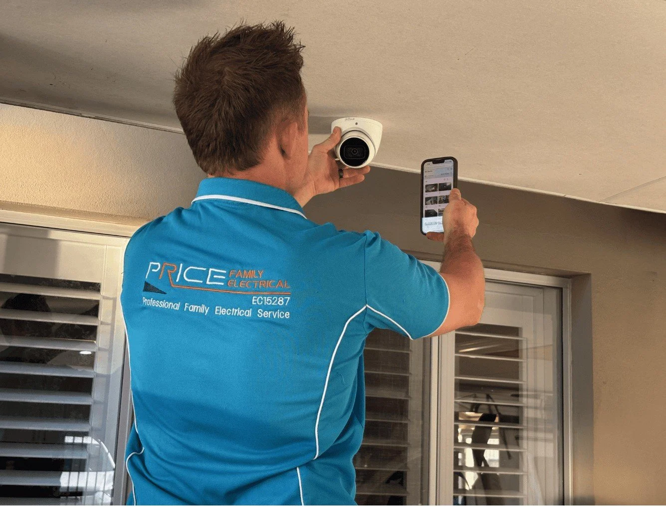 image of an electrician from Price Family Electrical installing a CCTV camera in a residential premise in Perth