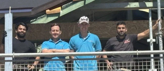 Four electricians from Price Family Electrical standing on a second storey of a renovated house in Perth