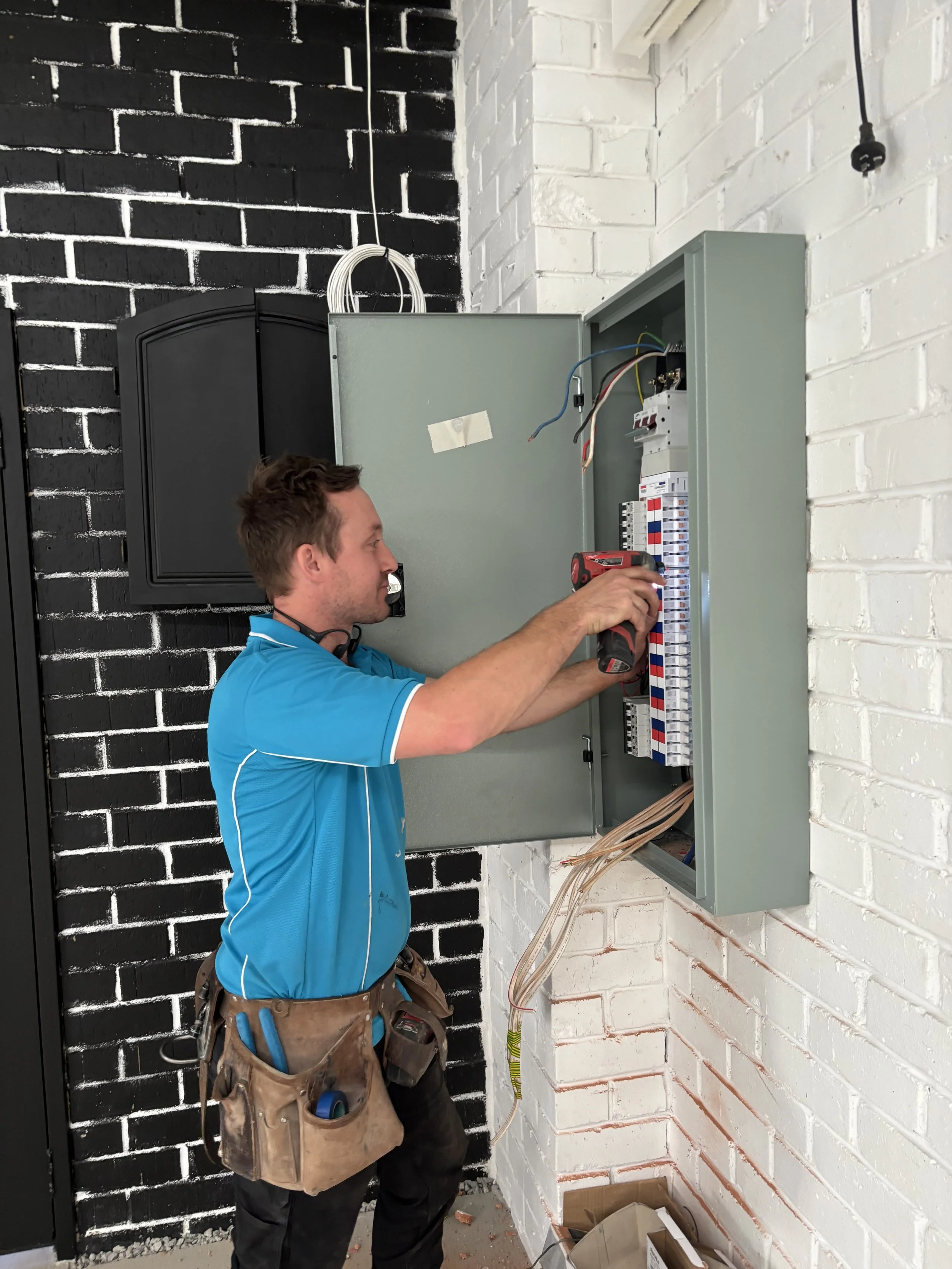 image of electrician from Price Family Electrical upgrading a commercial switchboard