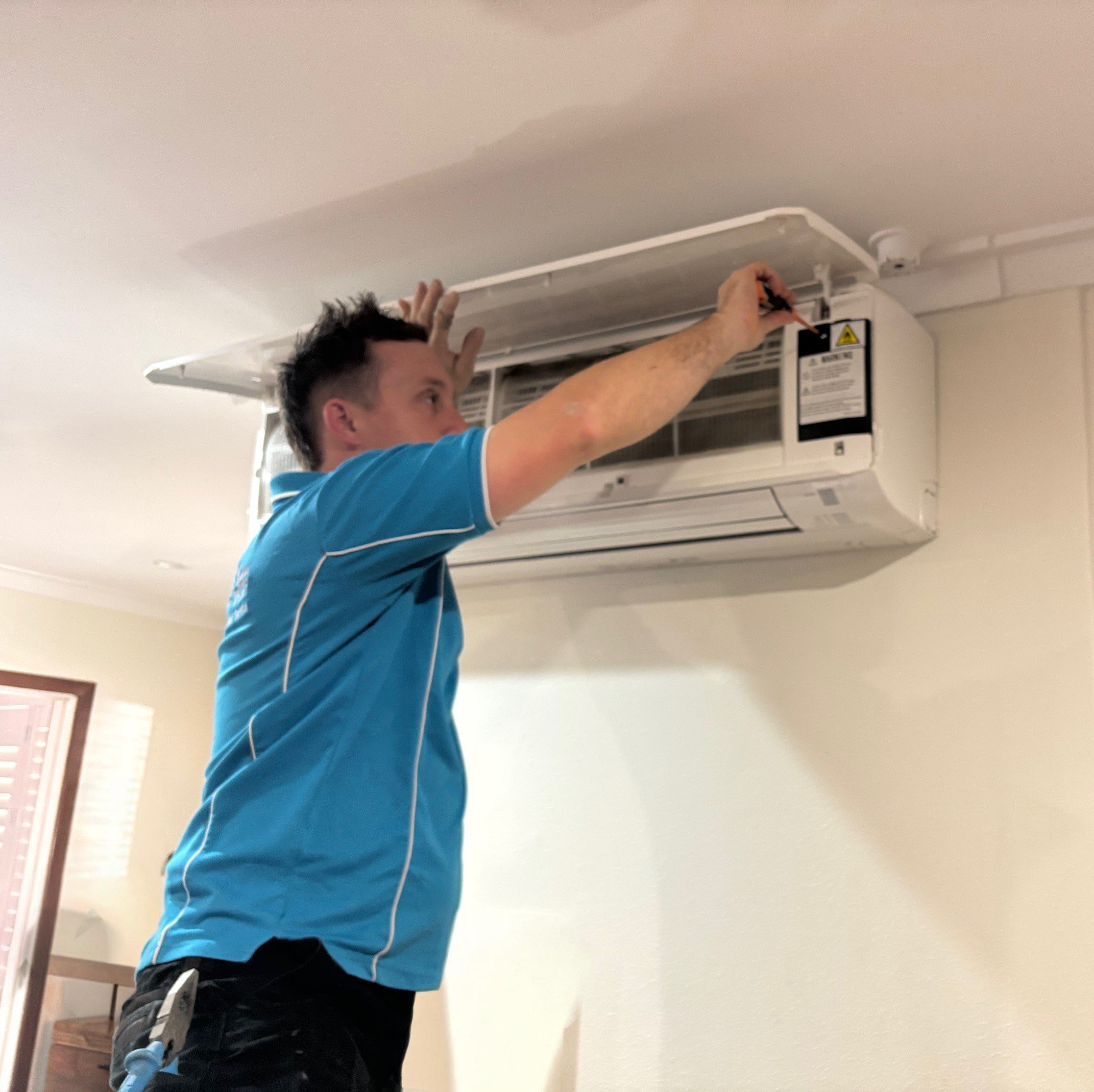 image of an electrician from Price Family Electrical installing a split-system air conditioner at a home in Perth 