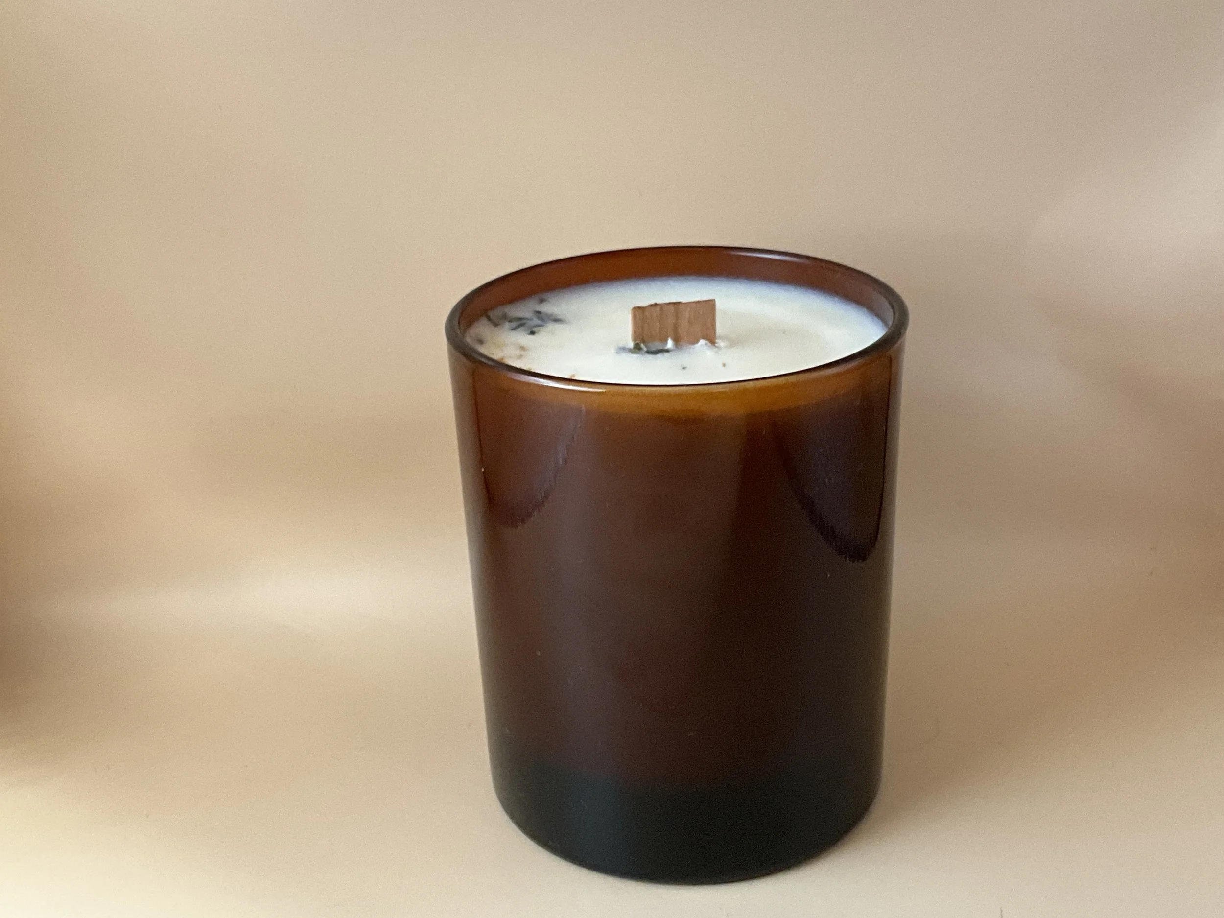 Amber glass candle, with white soy wax, some dried petals on top & a wooden wick