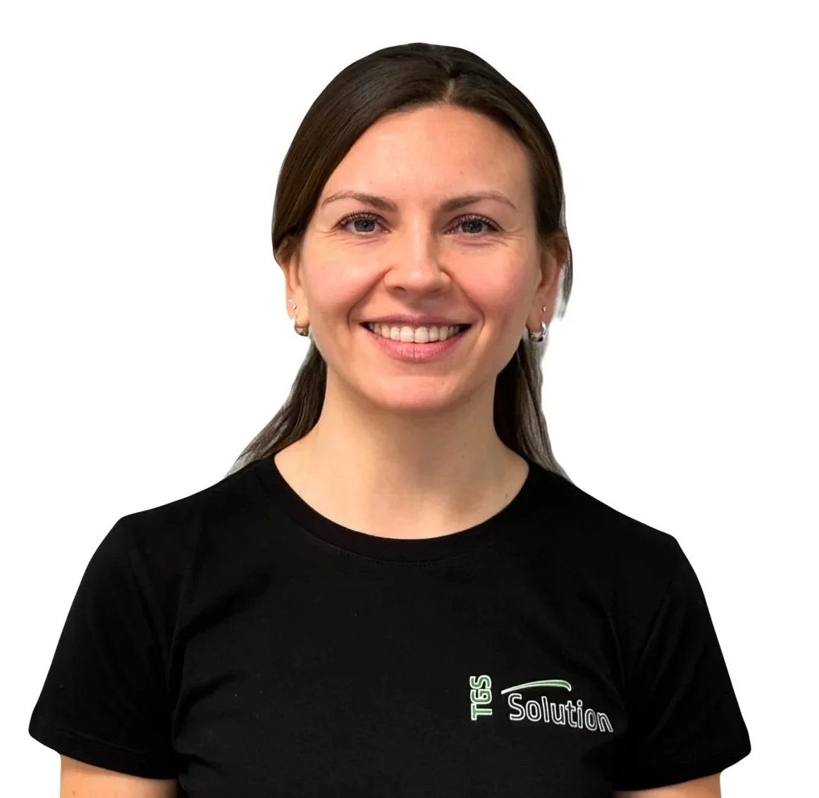 Bildet viser en smilende kvinne med langt brunt hår, iført en svart T-skjorte med Tekst 'TGS Solution', mot en hvit bakgrunn.
