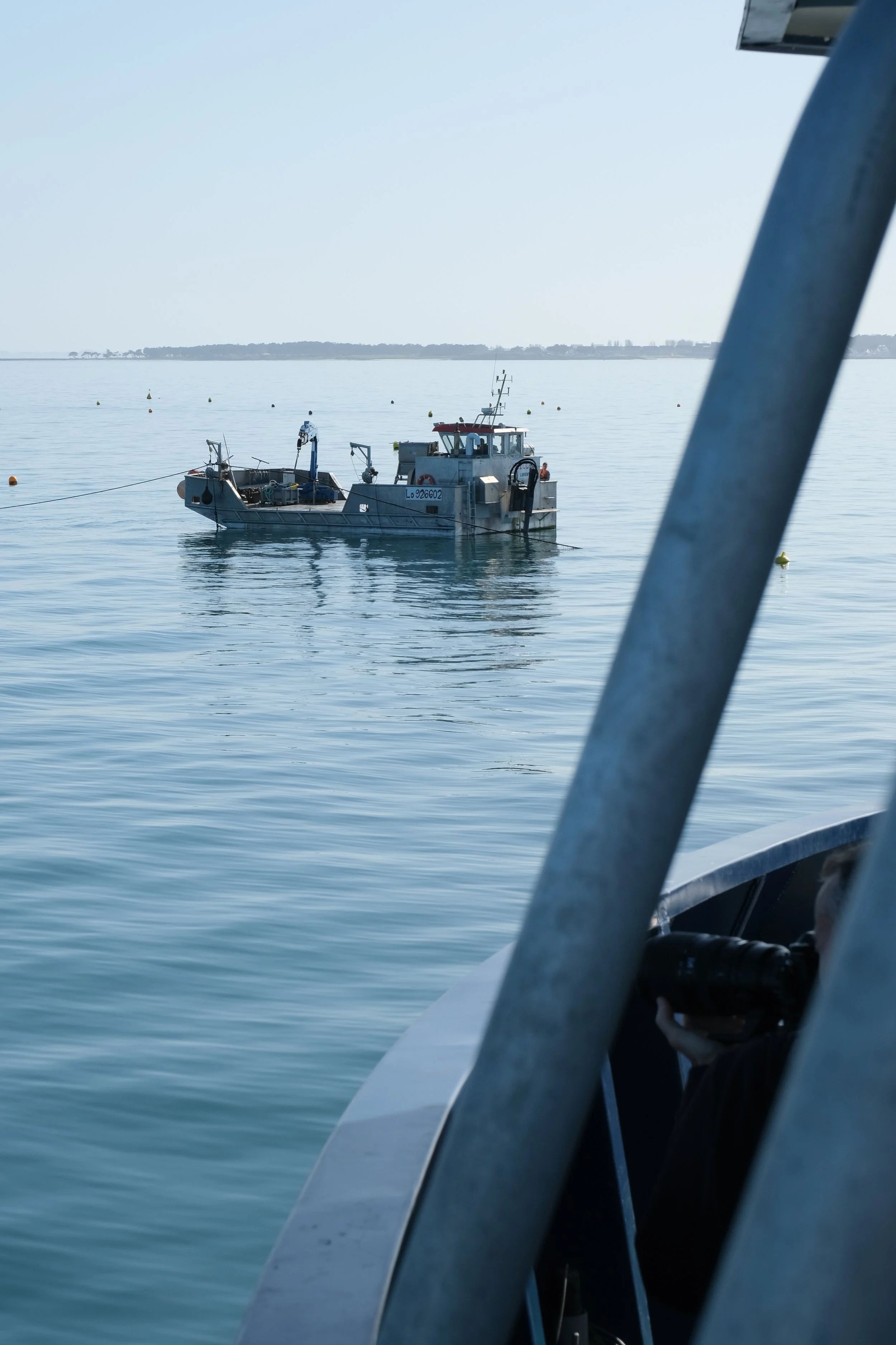 Vue d'un bateau en mer avec une autre embarcation visible en arrière-plan, prise depuis une autre embarcation.