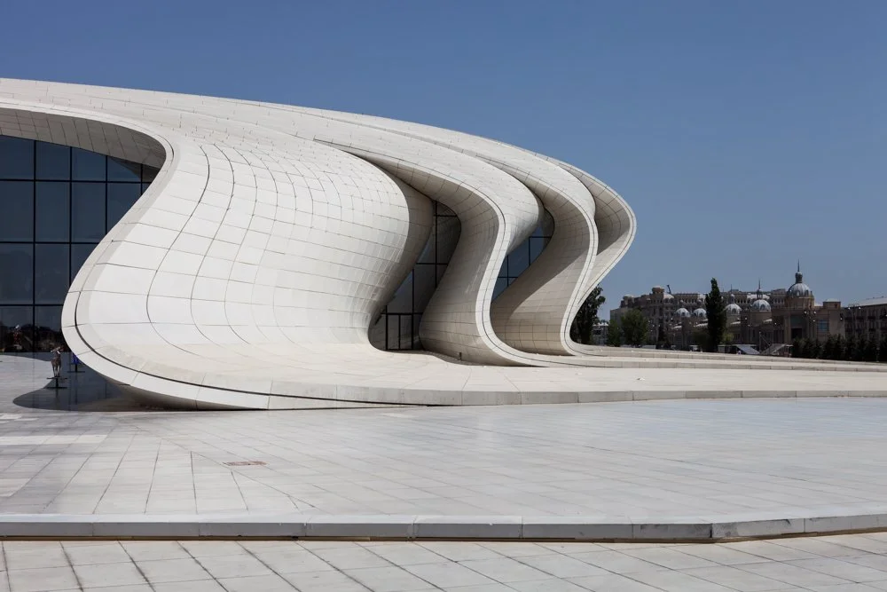 Centre Heydar Aliyev de Zaha Hadid à Baku, en Azerbaïdjan, une architecture moderne avec une façade blanche ondulée et des fenêtres vitrées.
