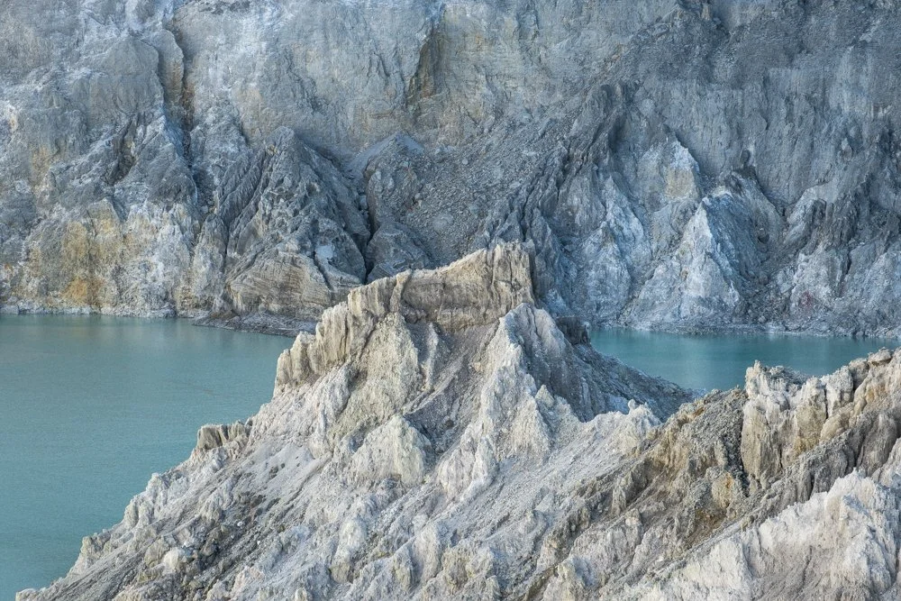 Lac bleu turquoise du Kawah Ijen entouré de montagnes rocheuses
