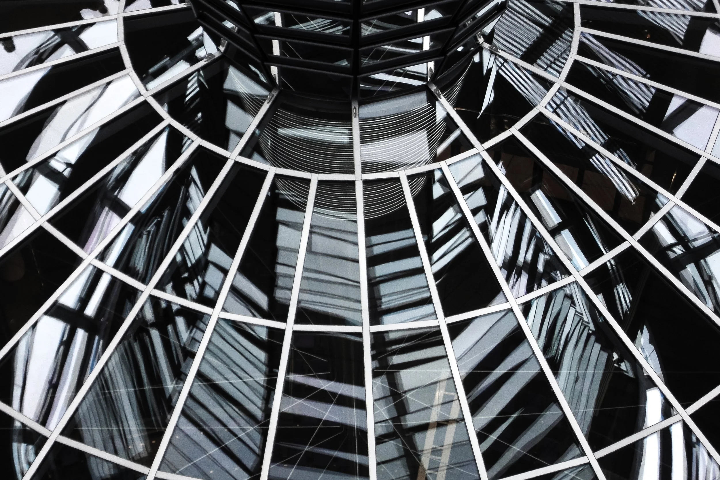 Vue du bas du Reichstag, bâtiment moderne en verre avec une structure métallique géométrique.