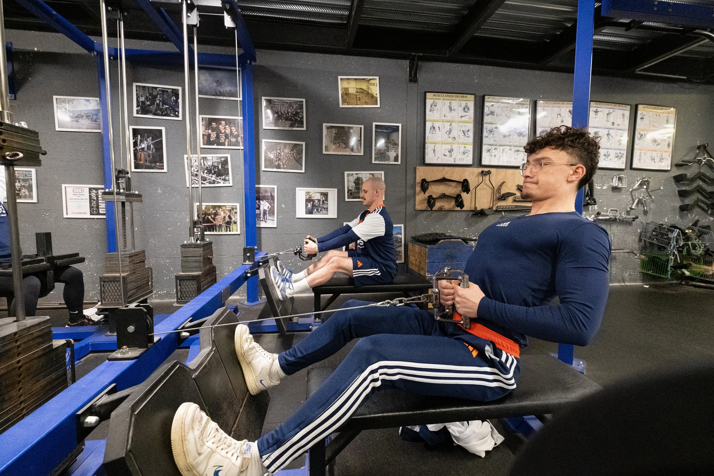 deux personnes faisant de l'exercice en utilisant des machines de musculation à la salle de sport.