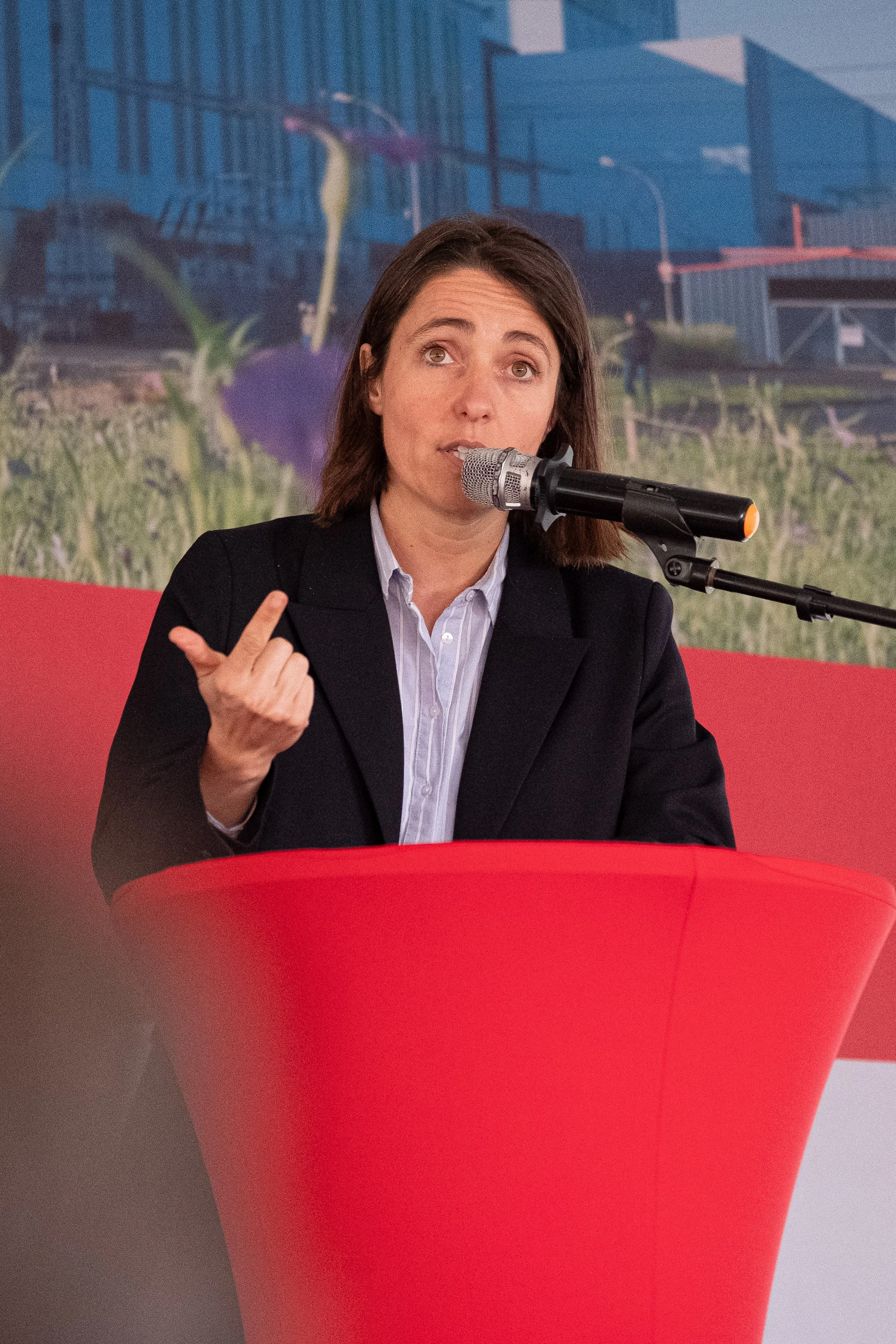Sophie Binet, présidente de la CGT, en costume noir parlant devant un microphone lors d'une conférence ou d'un discours.