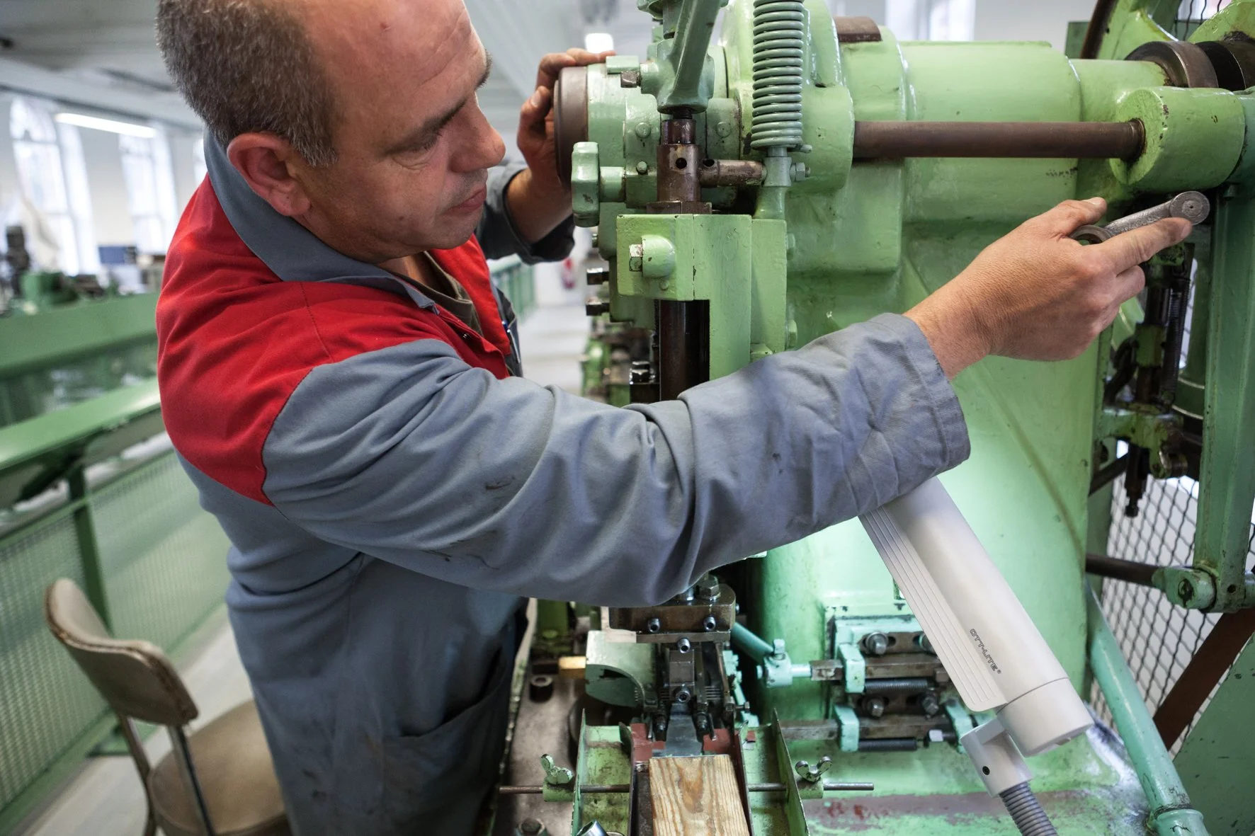 Un homme travaille sur une machine dans un atelier de fabrication.
