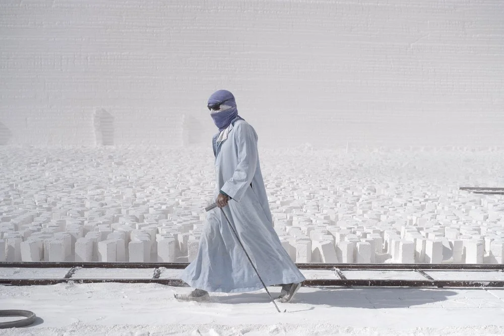 Egyptien en djellaba bleue dans un environnement blanc.