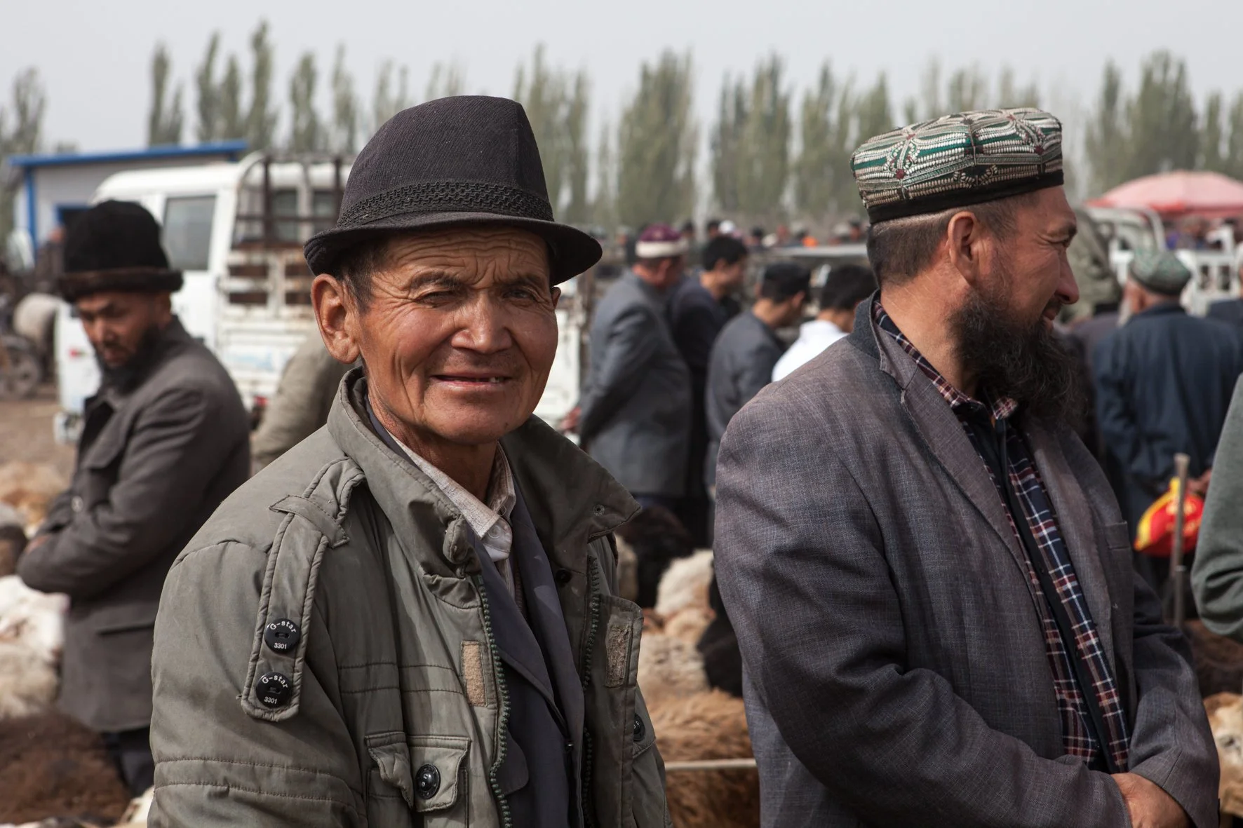 Deux hommes en vêtements traditionnels et modernes au marché de Kashgar en Chine.