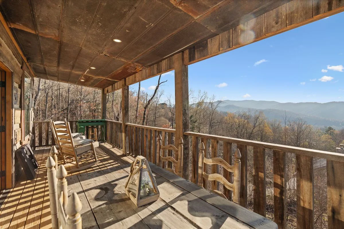 Deck at Melton’s View Cabin with rocking chairs overlooking sweeping Smoky Mountain views in Gatlinburg.