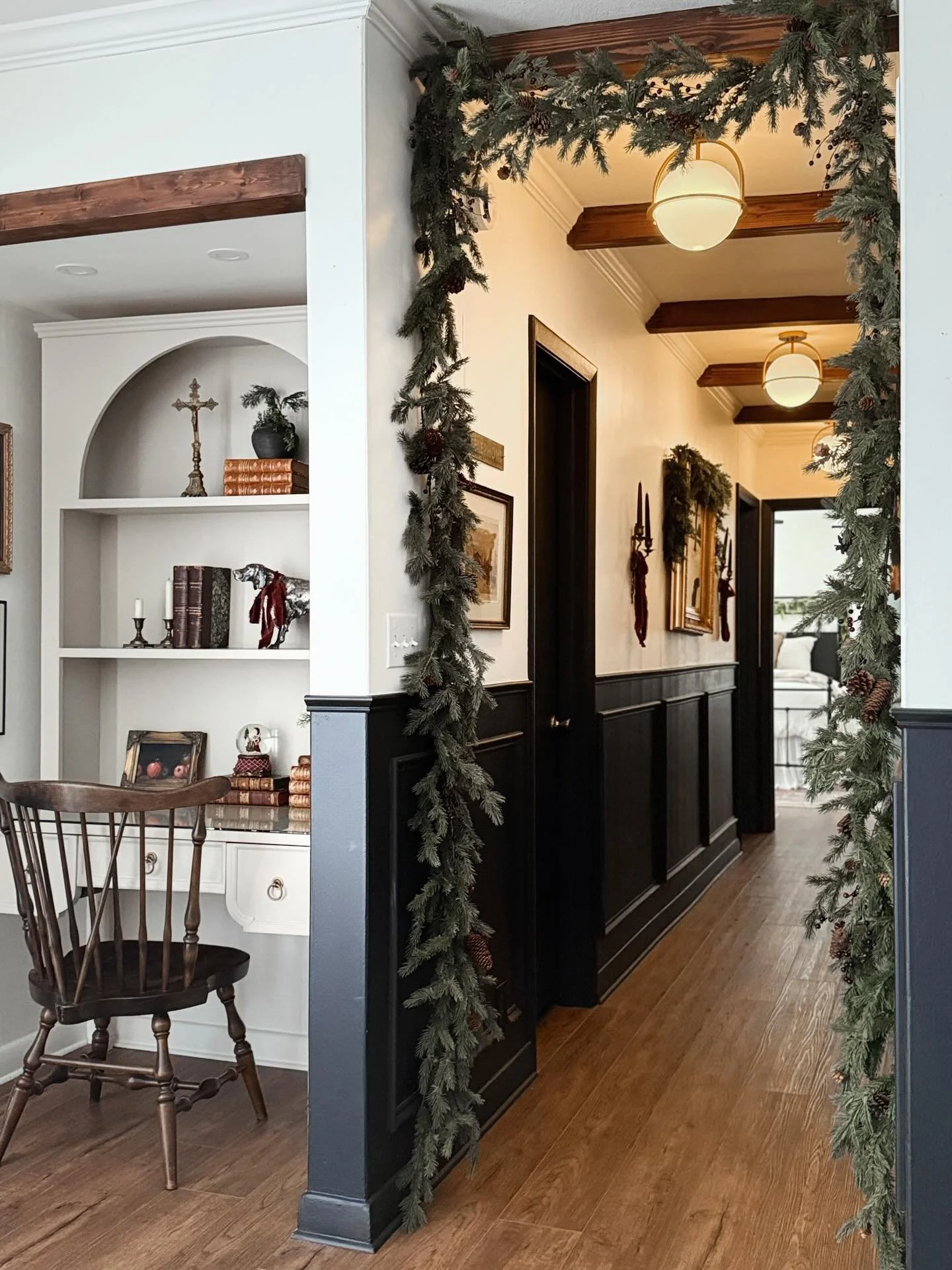 This corner is all about layering thoughtful holiday details. 🌲

In the hallway, I added strands of garland to frame the opening and added drapey velvet ribbon to my antique sconces for a subtle, classic touch.

I carried the same soft, understated 